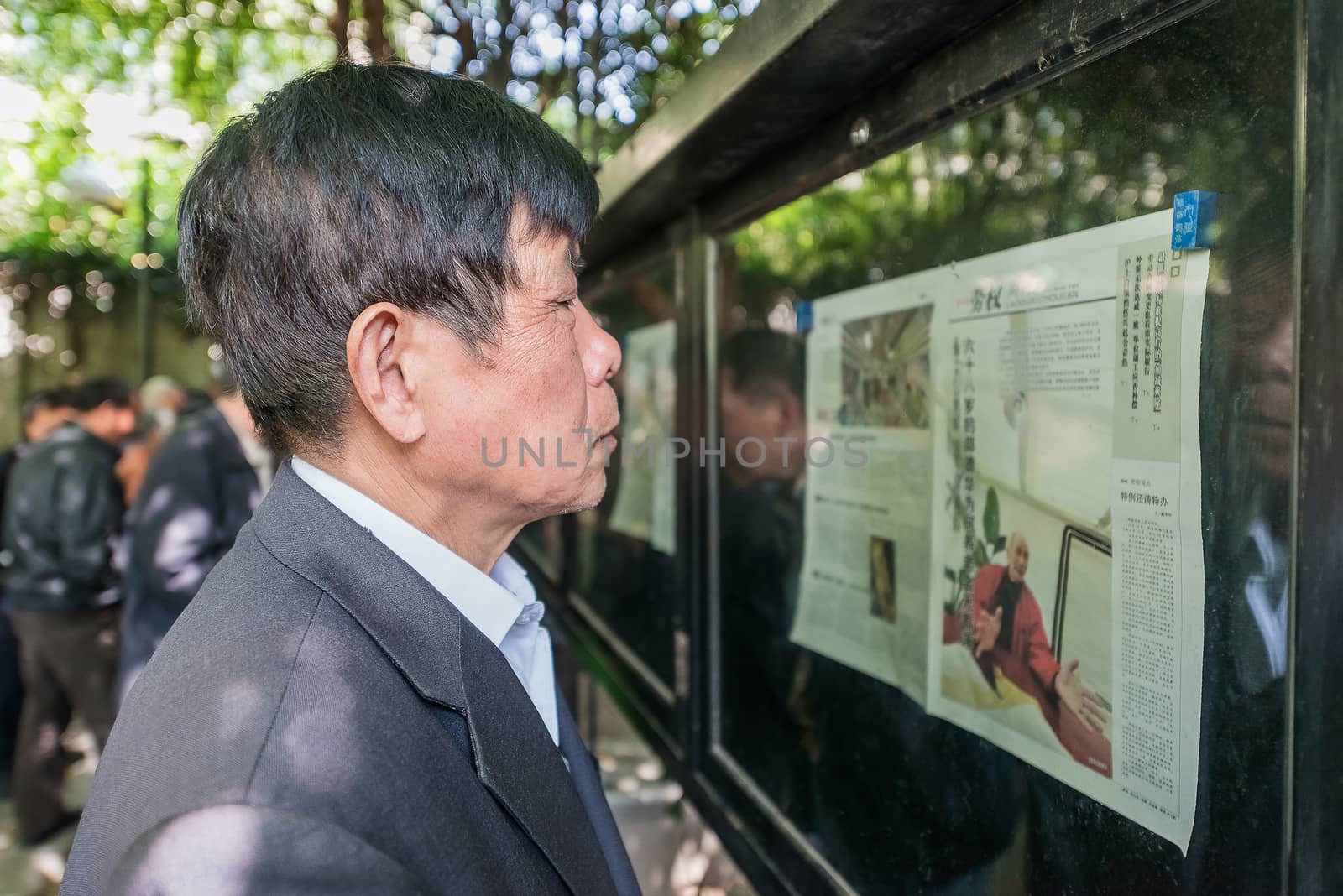 Shanghai, China - April 7, 2013: one man reading newspaper in fuxing park at the city of Shanghai in China on april 7th, 2013