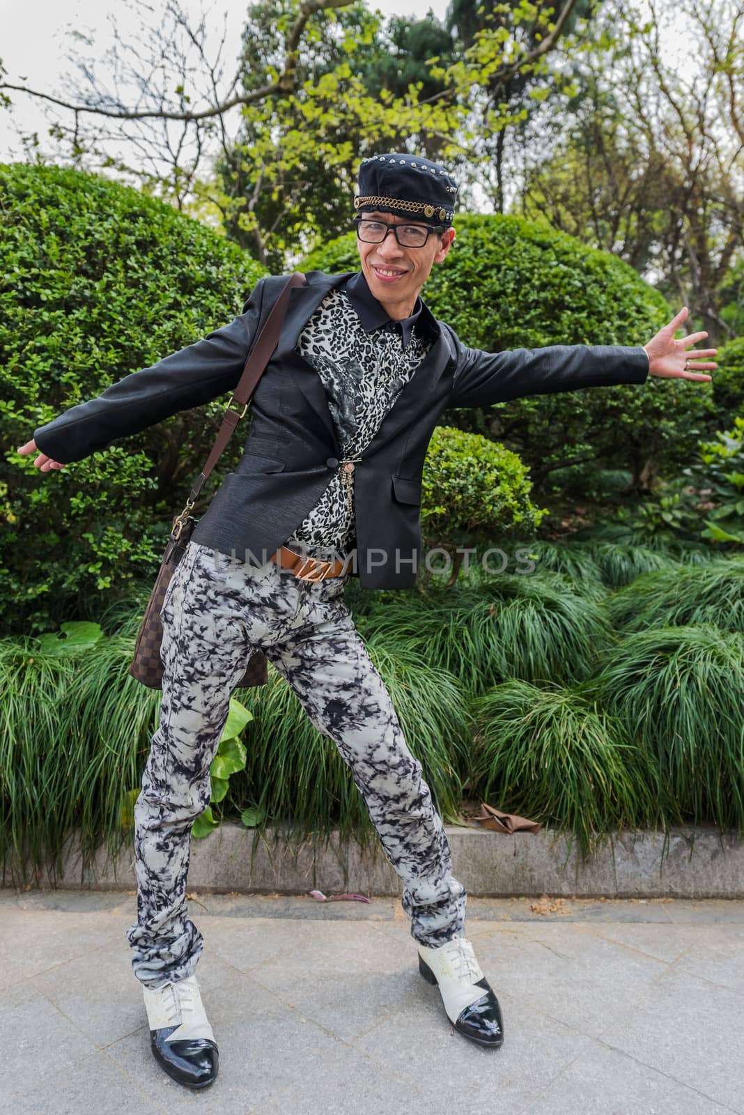 Shanghai, China - April 7, 2013: one stylish fashionable chinese man posing smiling at the city of Shanghai in China on april 7th, 2013