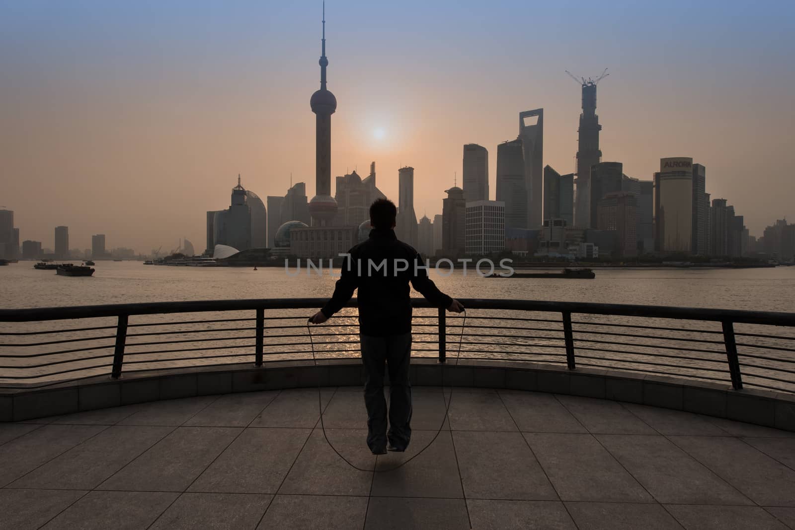 Shanghai, China - April 7, 2013: chinese man exercising jumping rope the bund waterfront at the city of Shanghai in China on april 7th, 2013