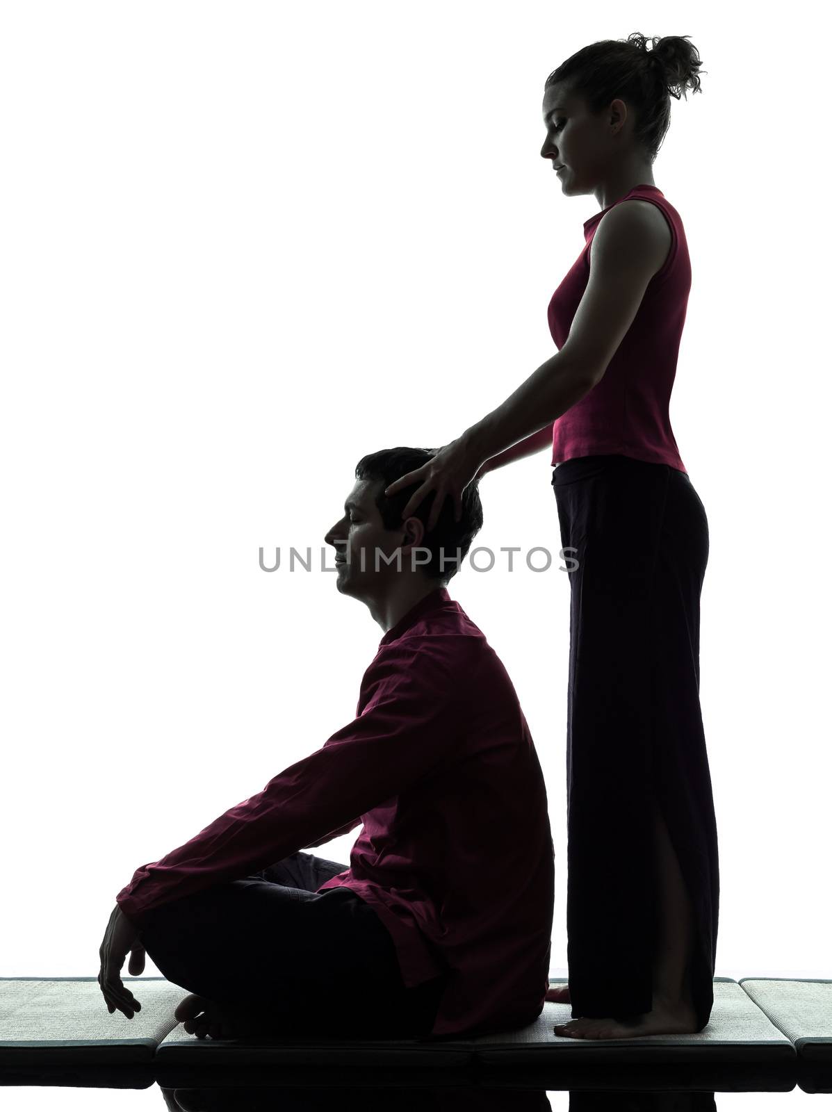 one man and woman performing thai massage in silhouette studio on white background