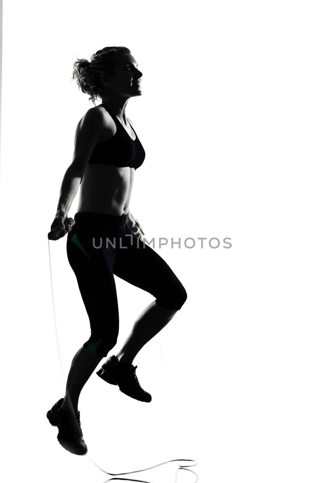 woman workout fitness posture body building jumping rope exercise exercising on studio isolated white background