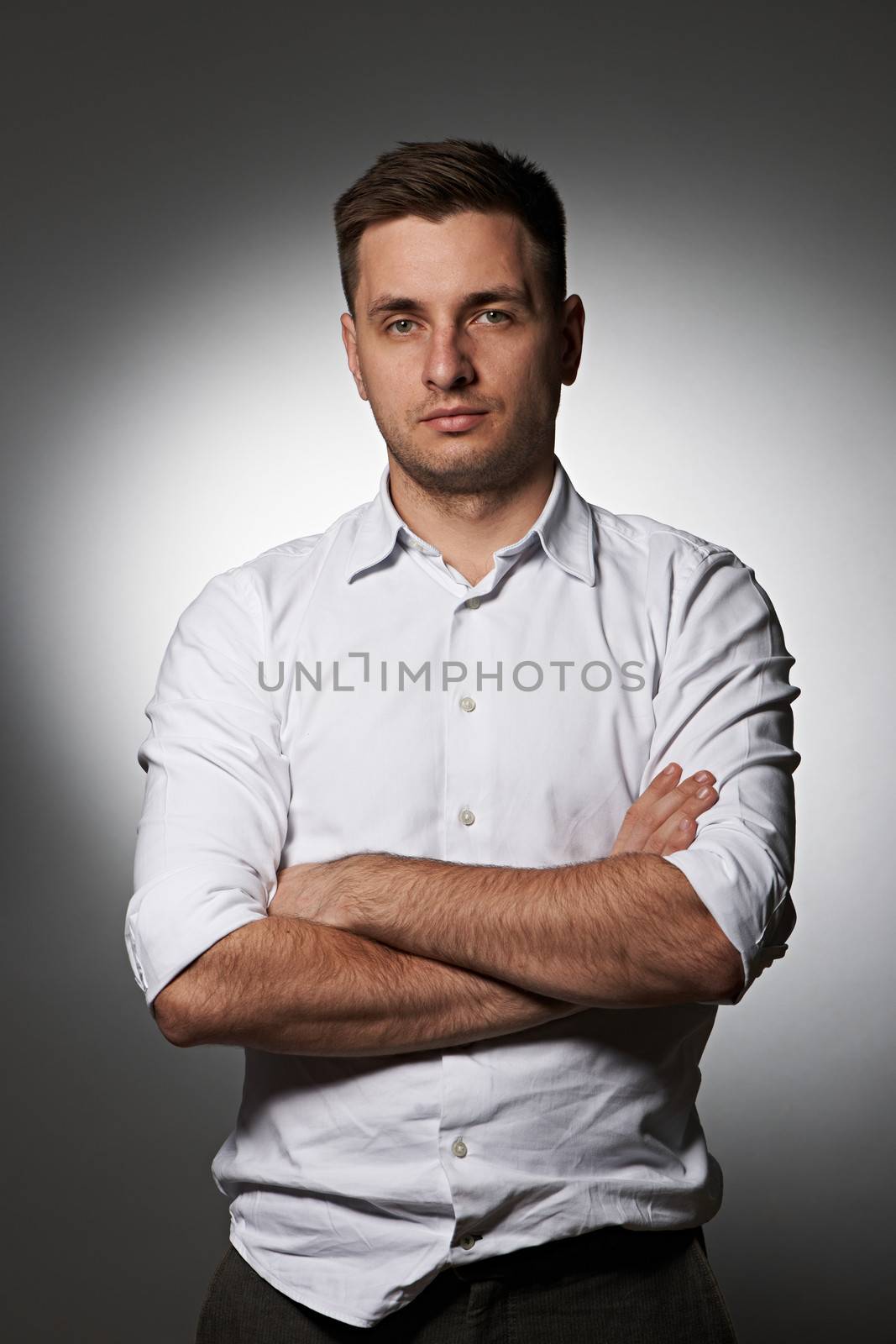 Portrait of serious man in shirt against grey by haveseen