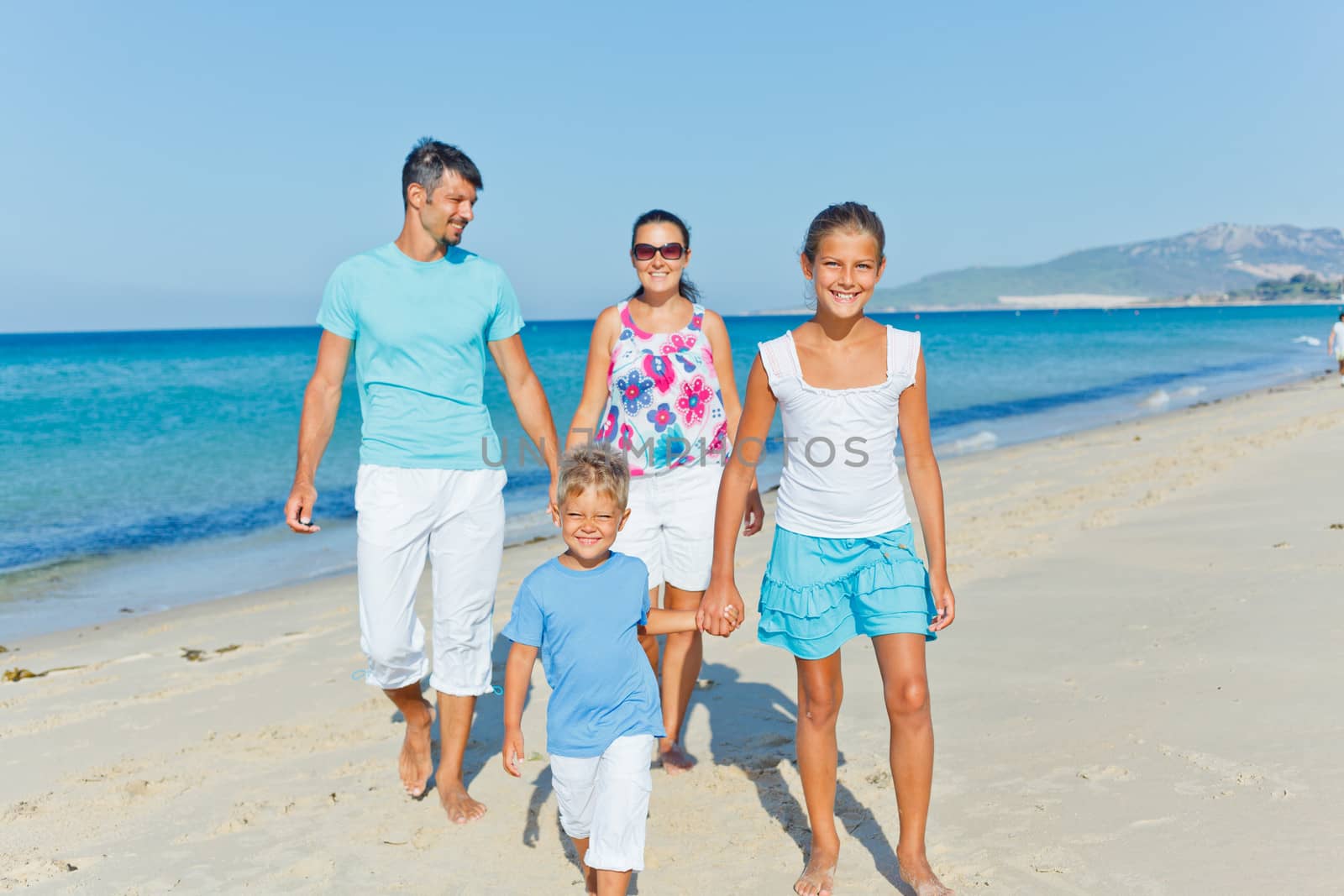 Family of four having fun on tropical beach