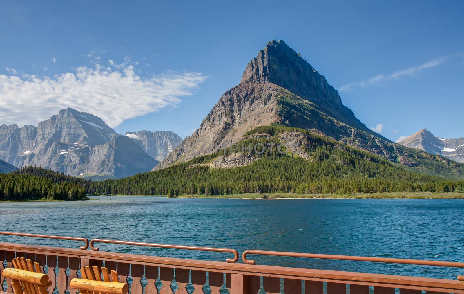 This image is looking directly across the Swiftcurrent Lake at Grinnell Point from the Many Glacier Hotel patio in Glacier National Park.