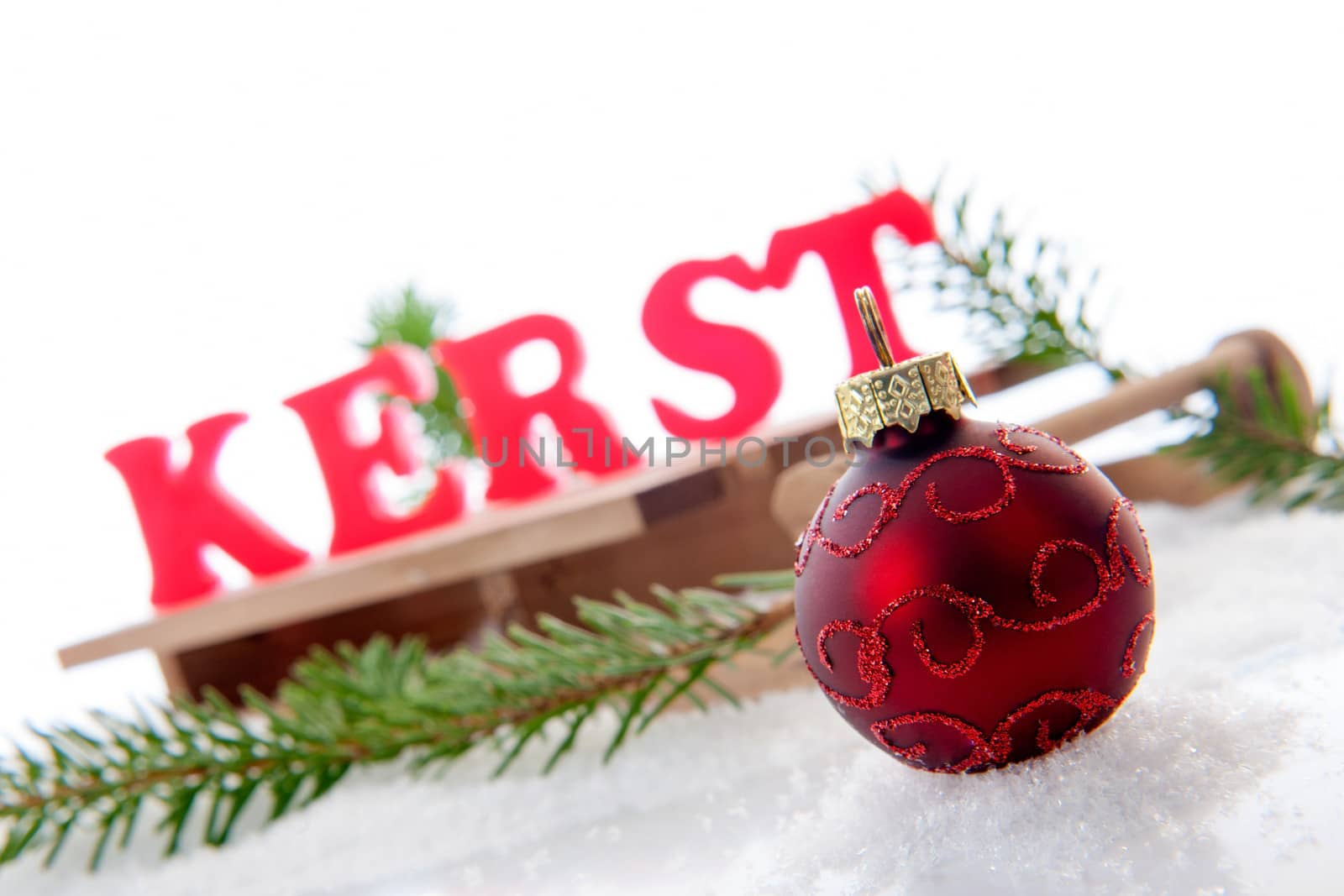 Red christmas ball in the snow, in the back the dutch word for Christmas " kerst " 