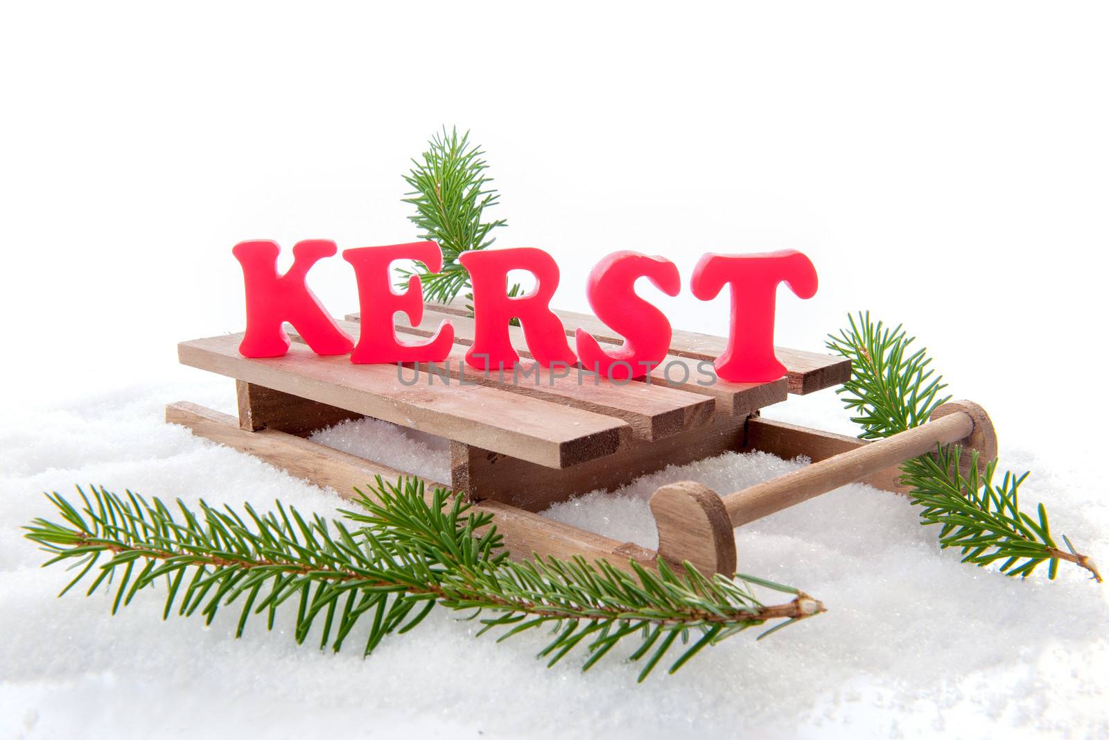The dutch word for christmas "kerst", red letters on a sleigh, with a pine branch