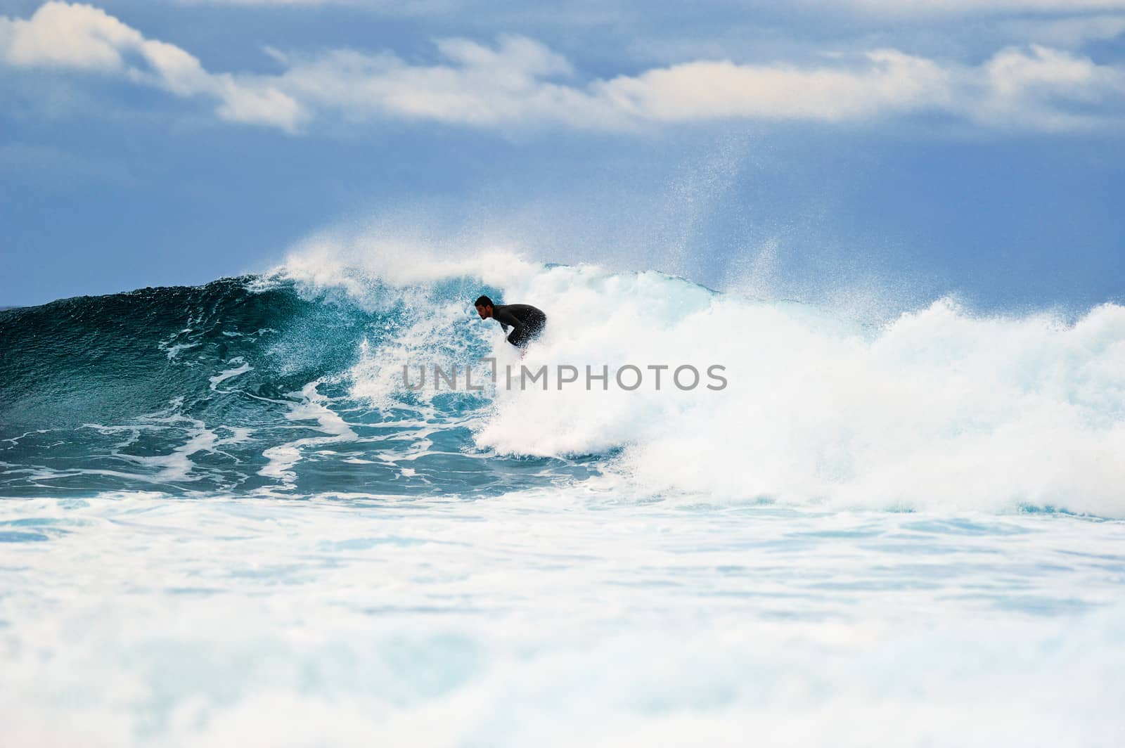 Surfer riding on a large wave on the Atlantic Coast. Canary island, Spain
