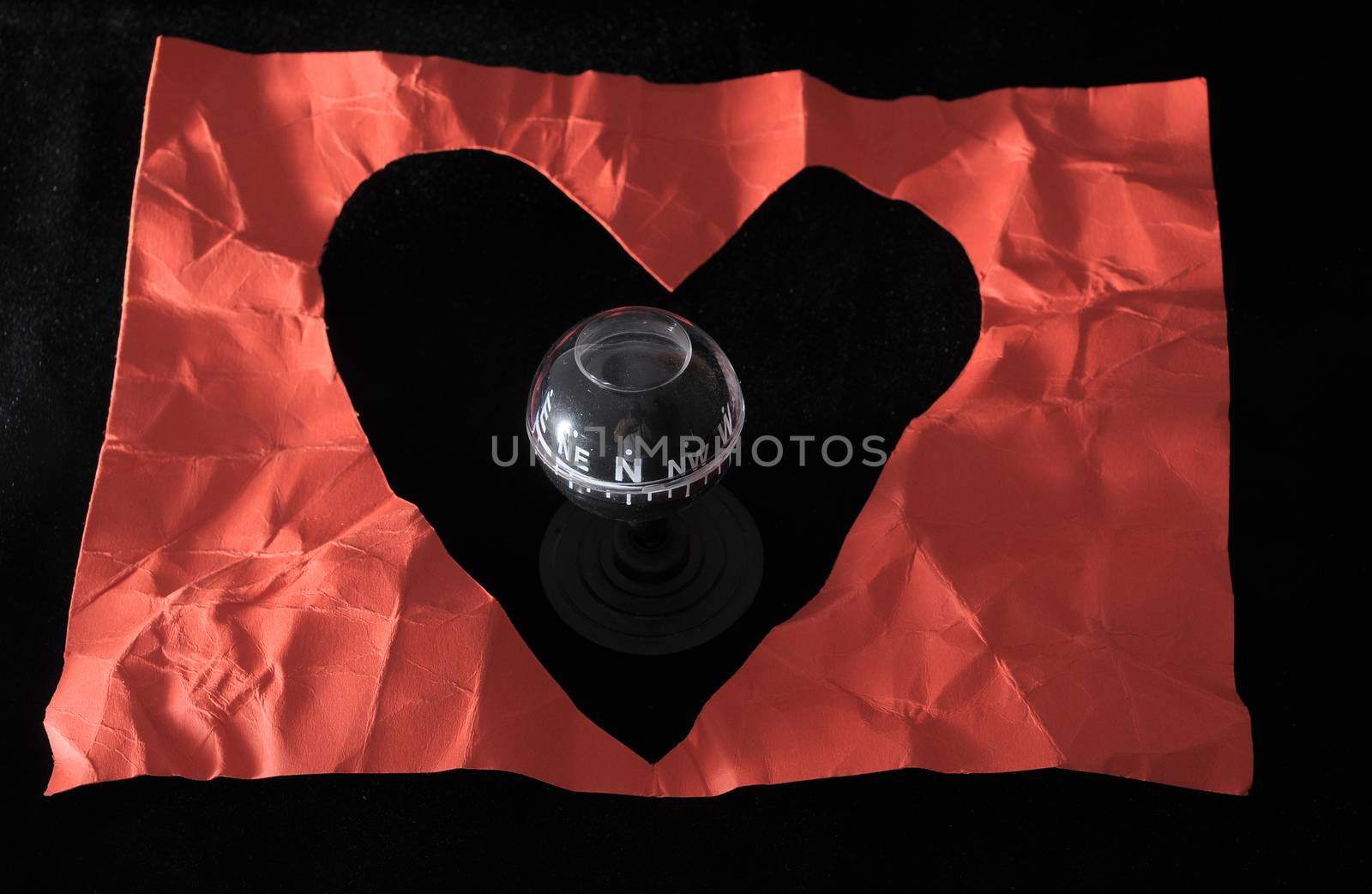 Orientation in Love - Red Paper Heart and Compass on a black Background