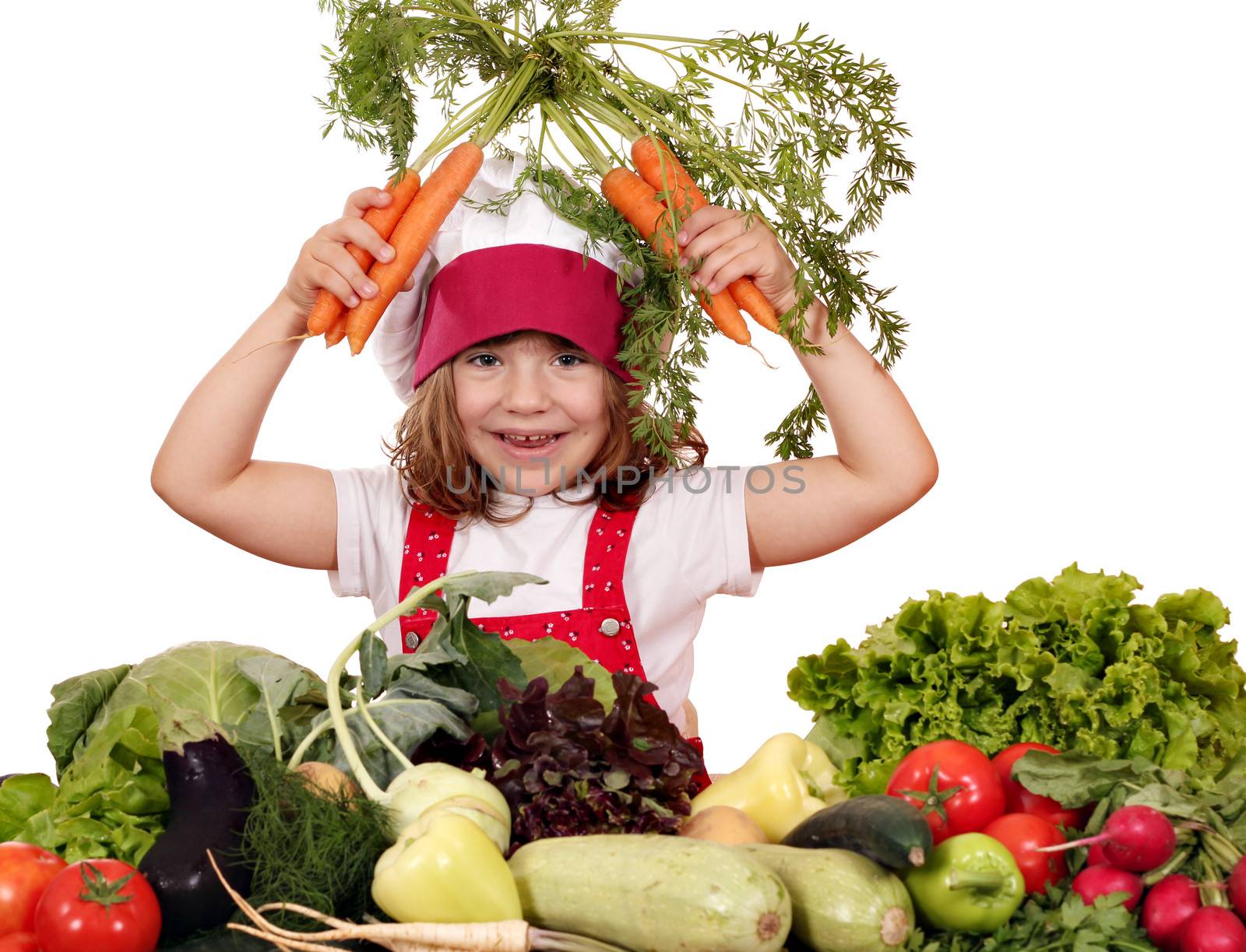 happy little girl cook with carrots and vegetables by goce
