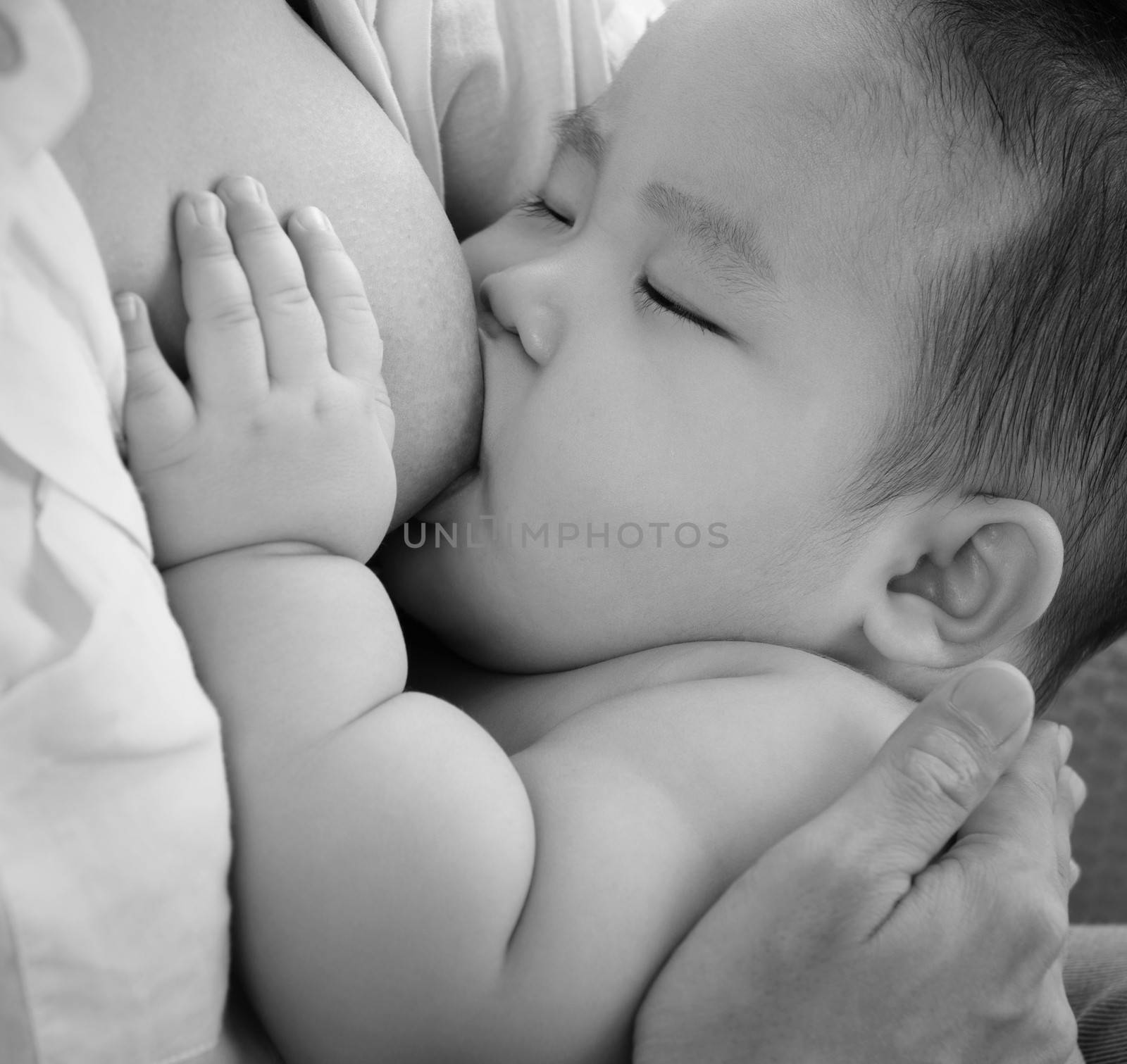 Mother and baby. Close up Asian mother breastfeeding baby boy in black and white tone.