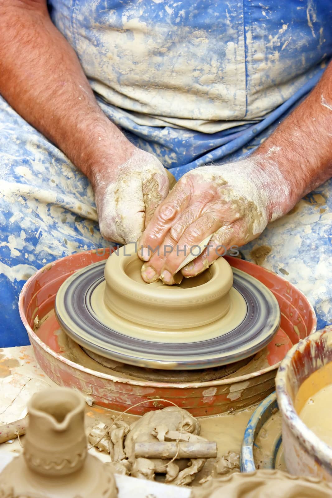 Close up of potter's hands making clay pot