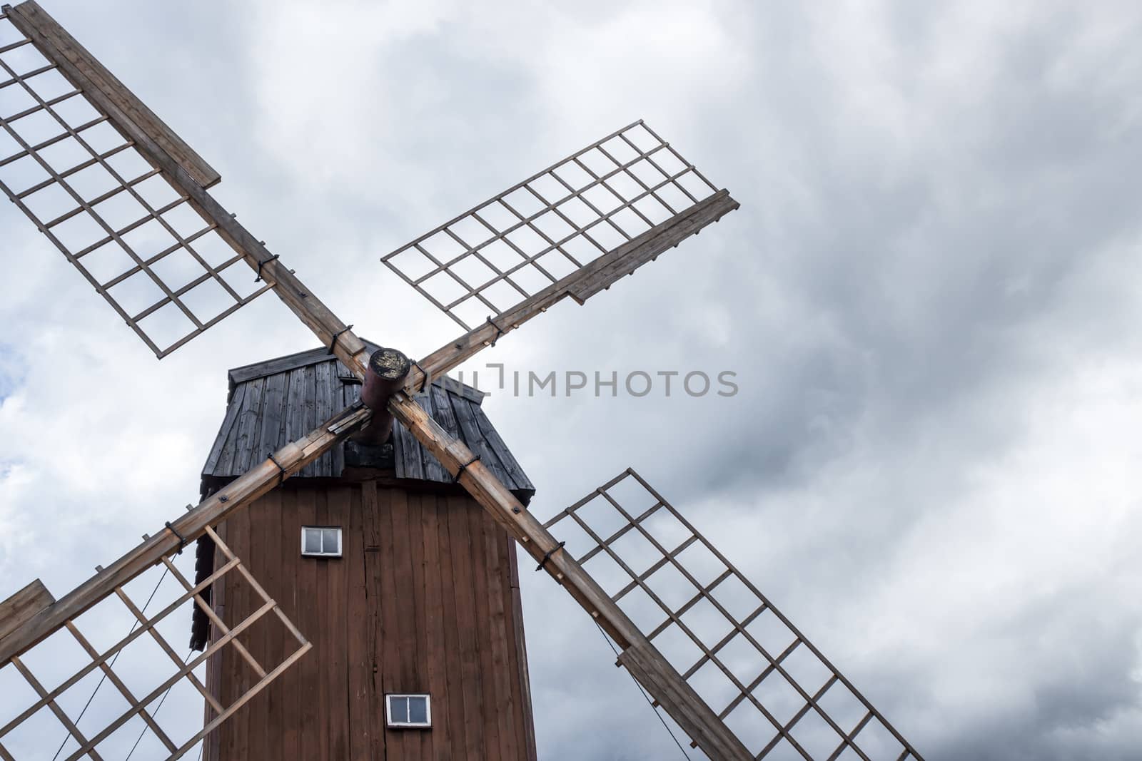 Old wooden windmill under the cloudy sky. Sweden.