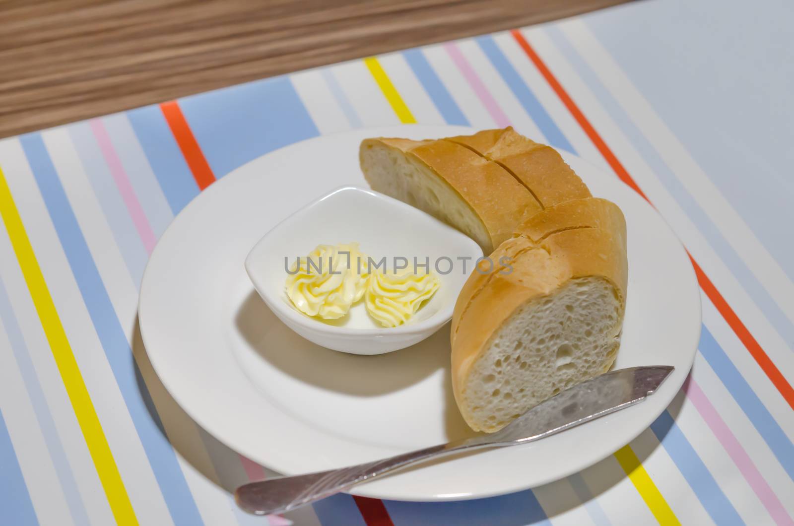 cheese in bowl  and slice of bread  on white plate
