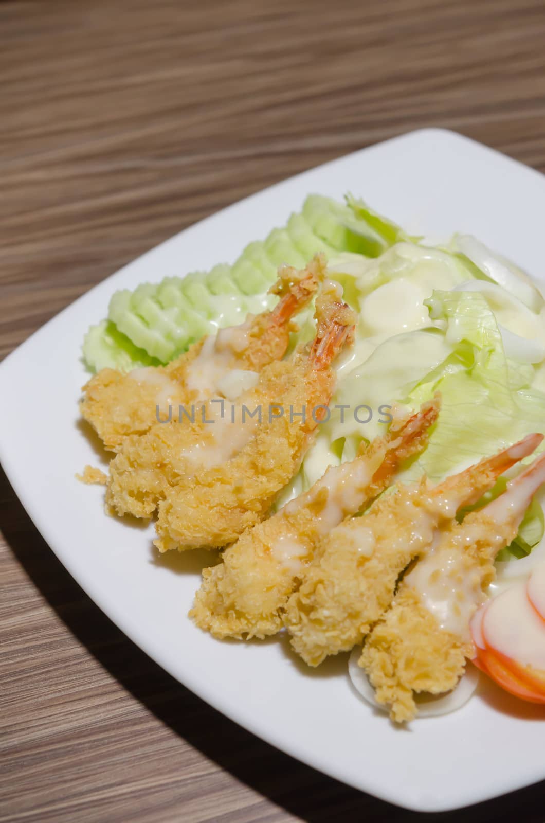 deep fried shrimp and  fresh vegetable salad with cream sauce on dish