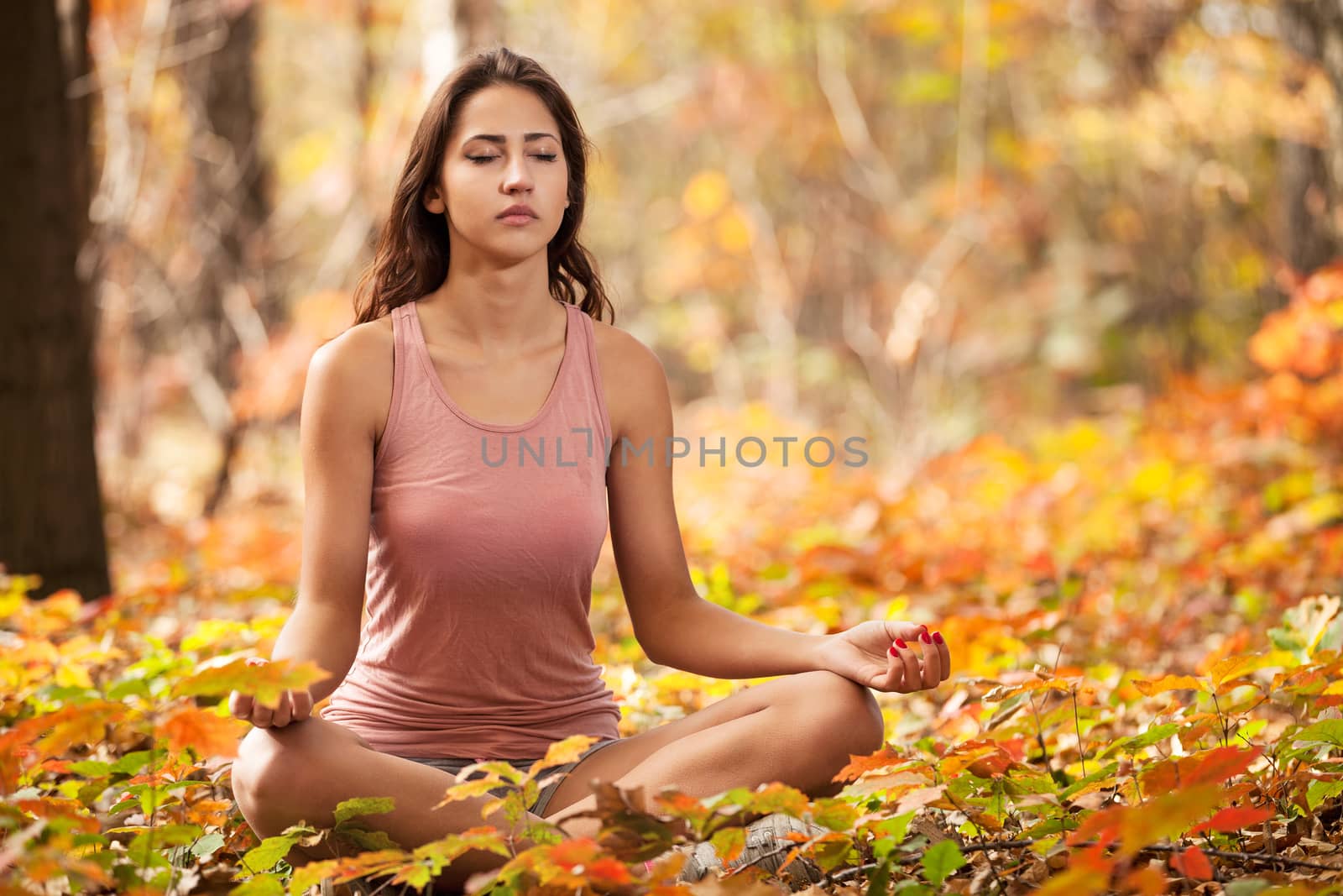 Young girl meditating in autumn park by photobac