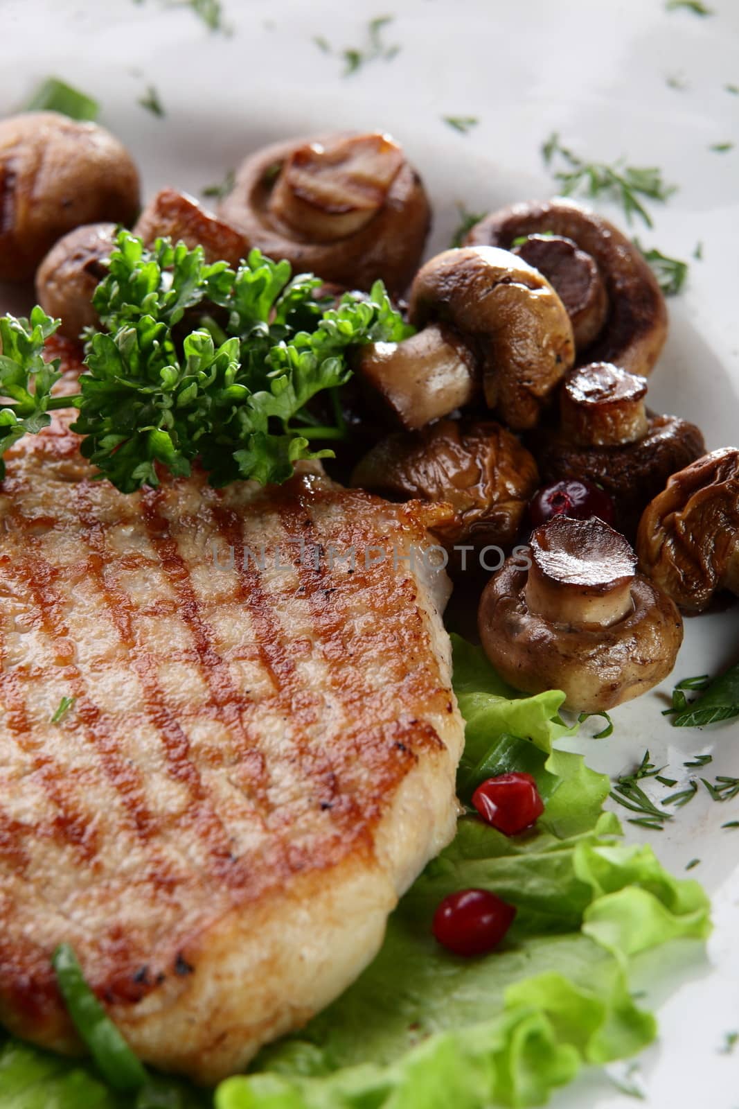 roated meat with mushrooms on white dish