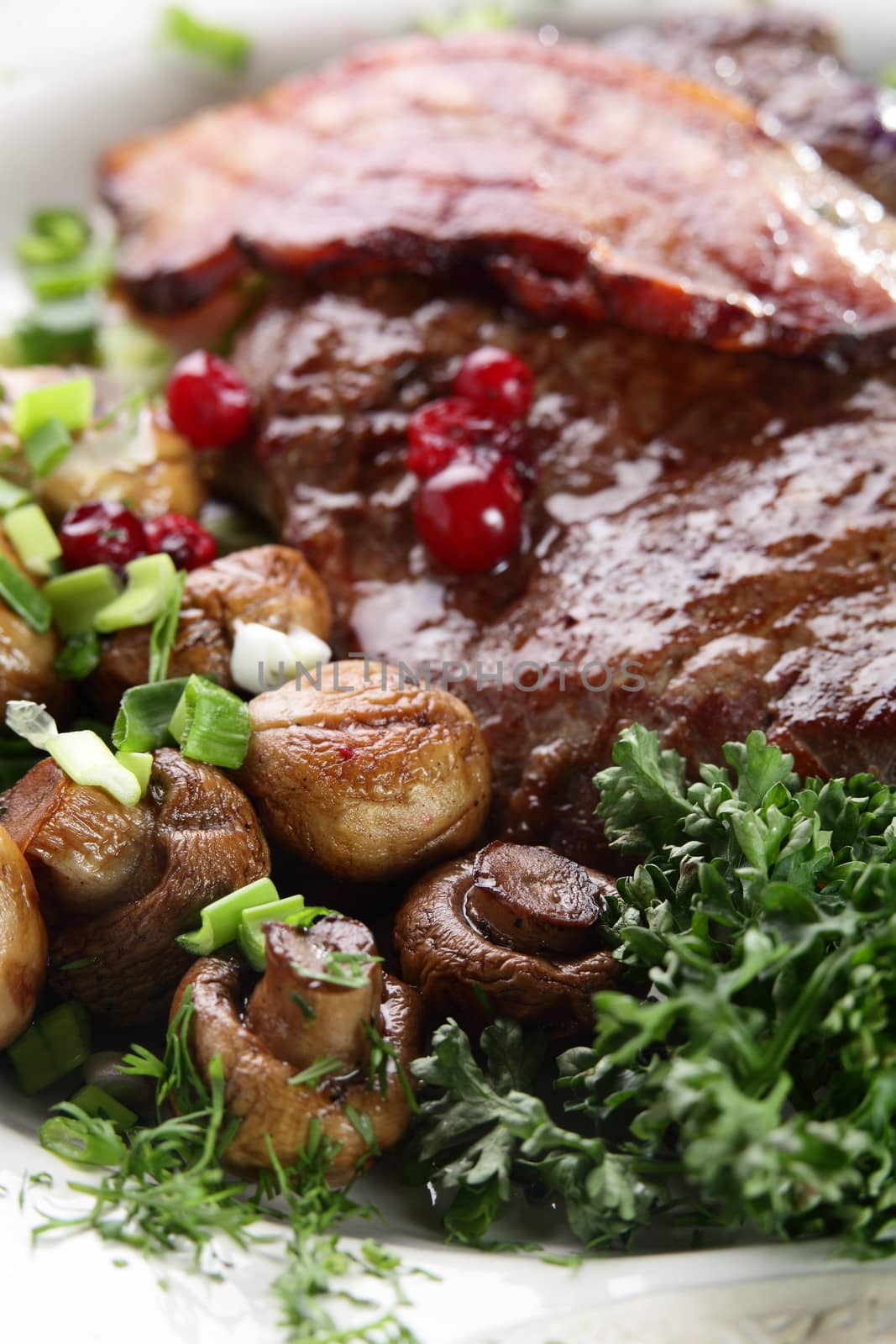 roated meat with mushrooms on black dish