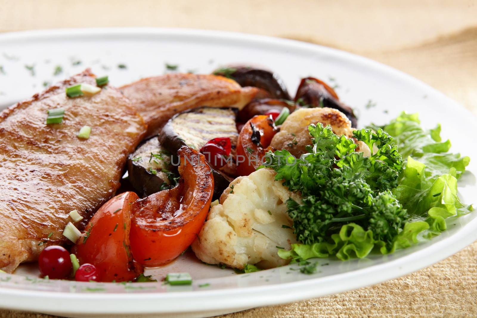 roated meat with mushrooms and vegetables on white dish