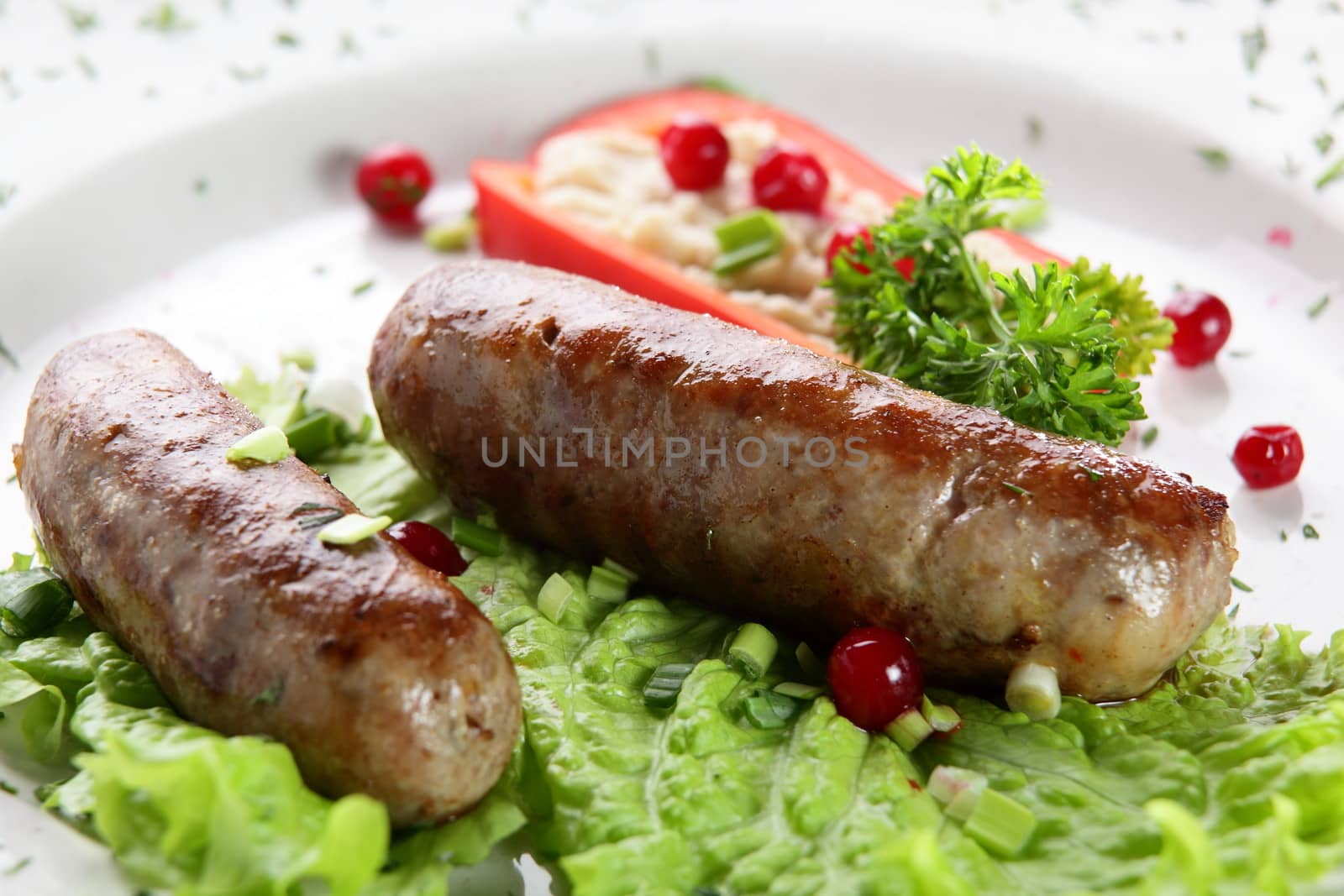 roasted sausages with pepper and berries in white pan