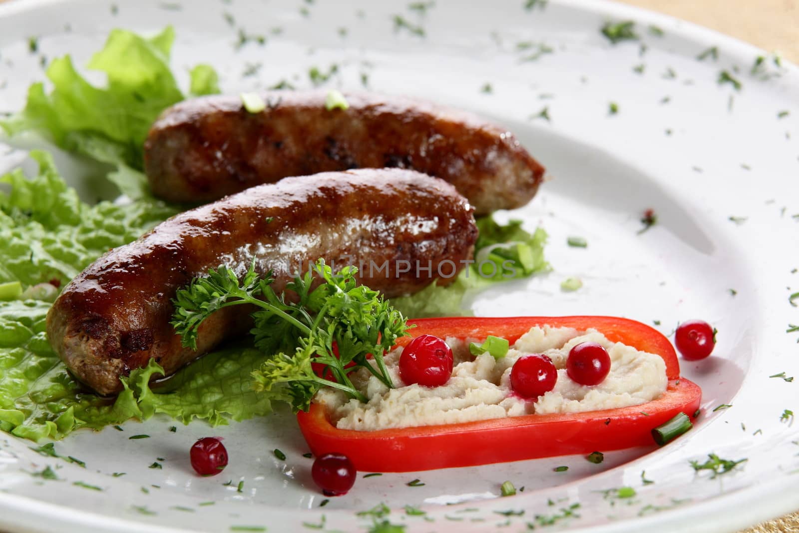 roasted sausages with pepper and berries in white pan