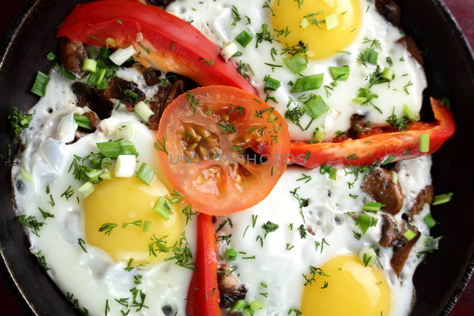 eggs with pepper and tomato on black pan