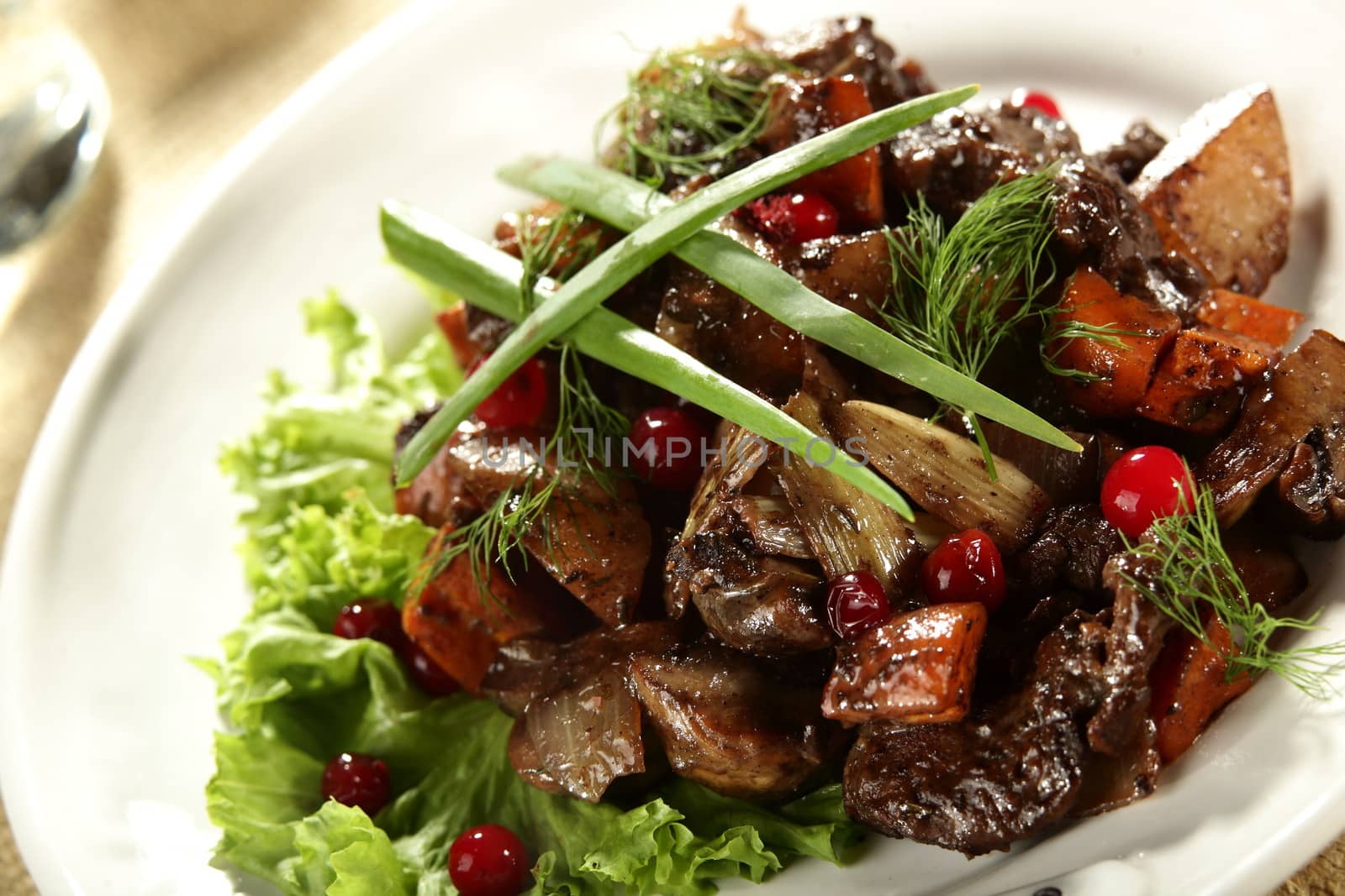 salad with meat and berries on the white dish