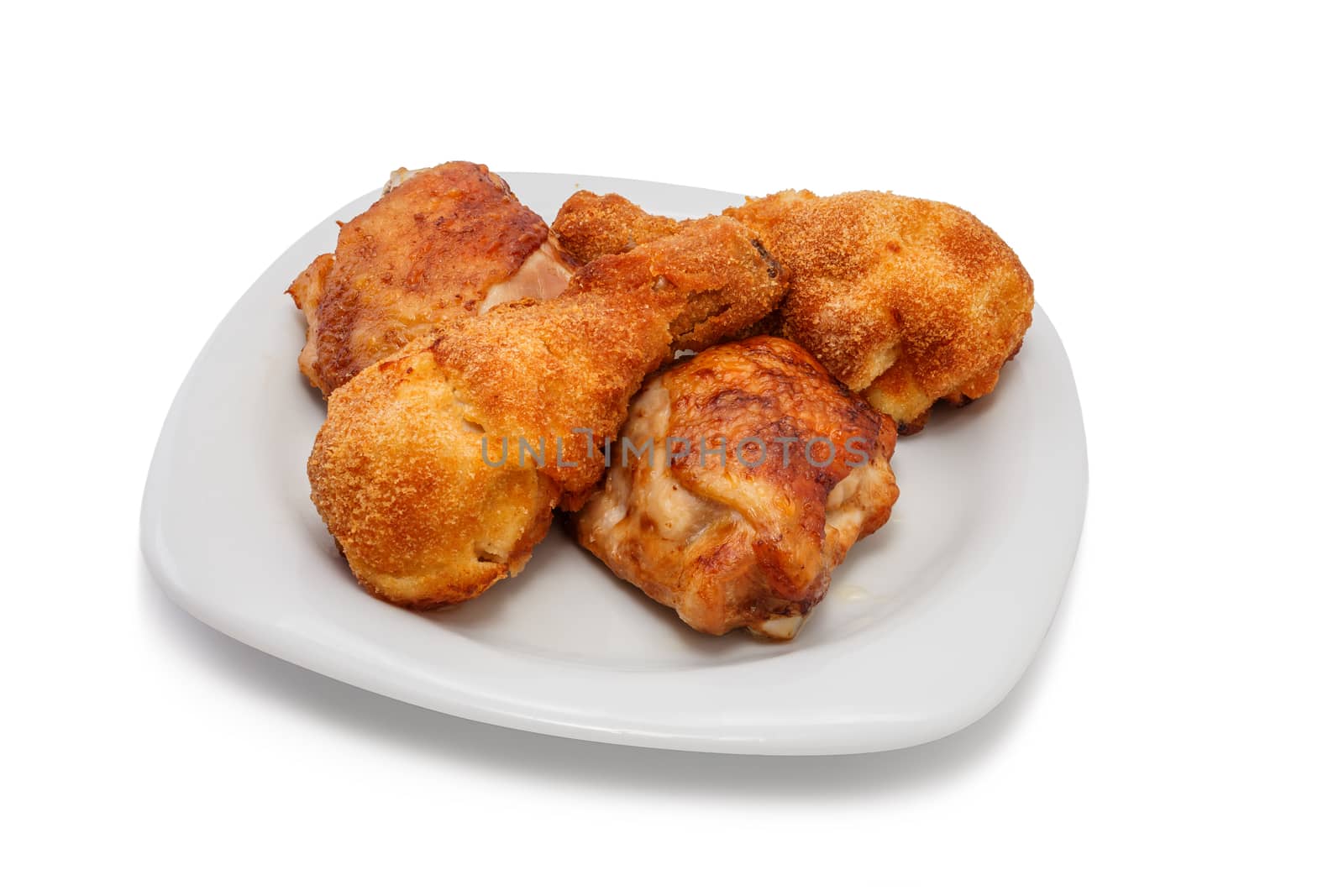 Fried chicken pieces on a plate. Taken on a sheet of white plastic. Is not an isolate.