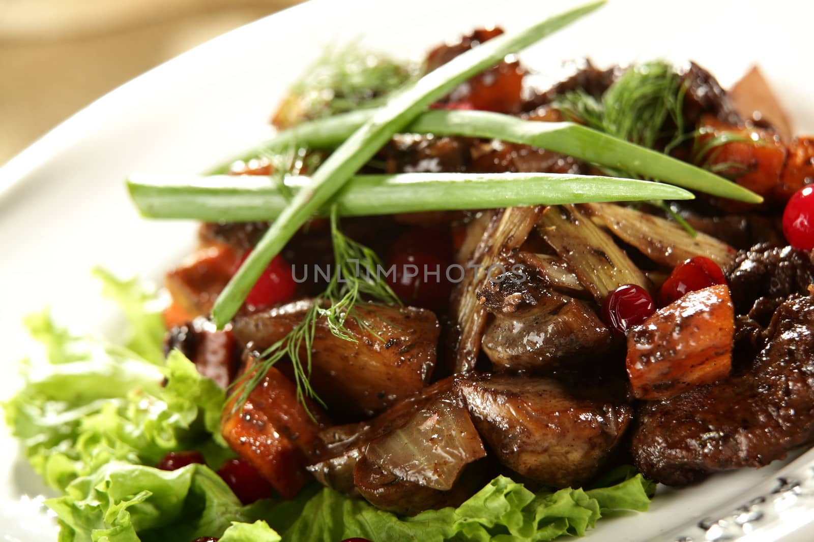 salad with meat and berries on the white dish