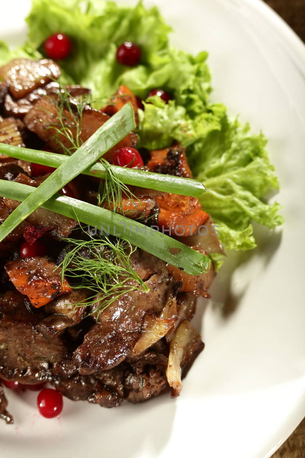 salad with meat and berries on the white dish