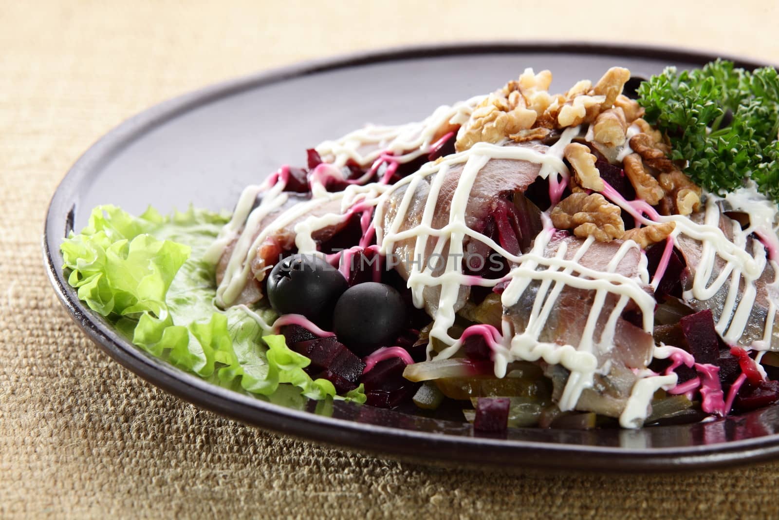 salad with fish and nuts in black dish