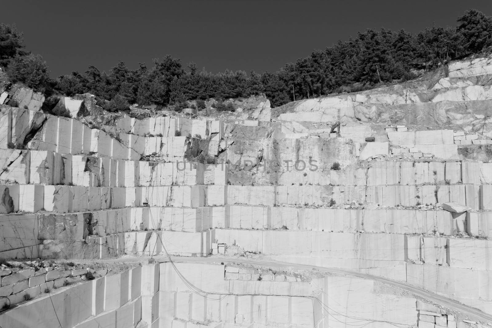 Detail of huge Thassos white marble quarry (mine) with grabber in bw color