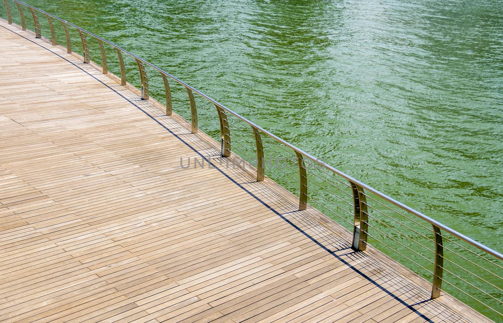 Wooden floor on riverbank by gjeerawut