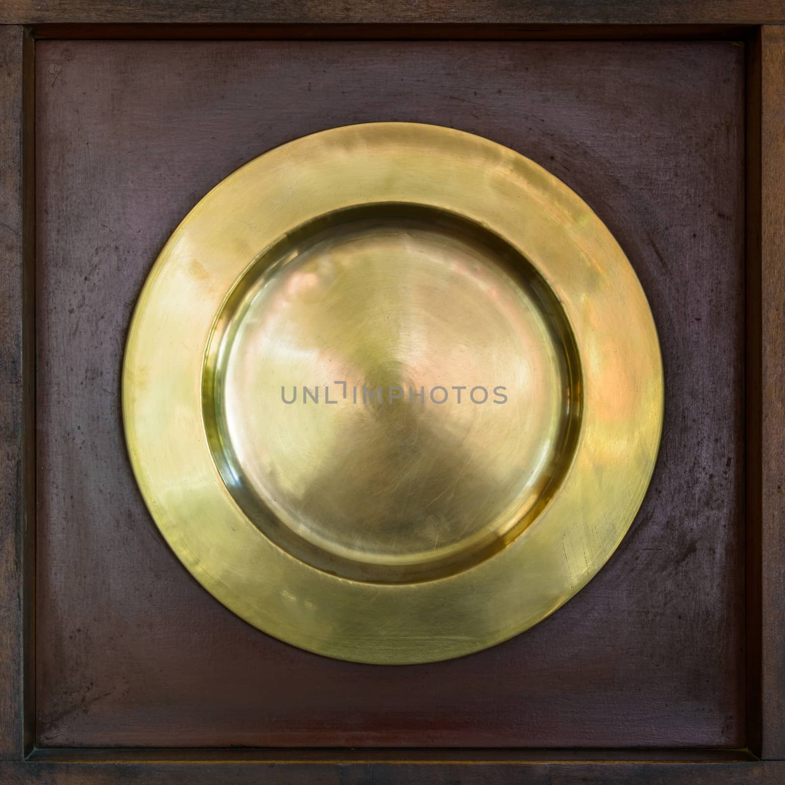 Brass plate on a square wooden background
