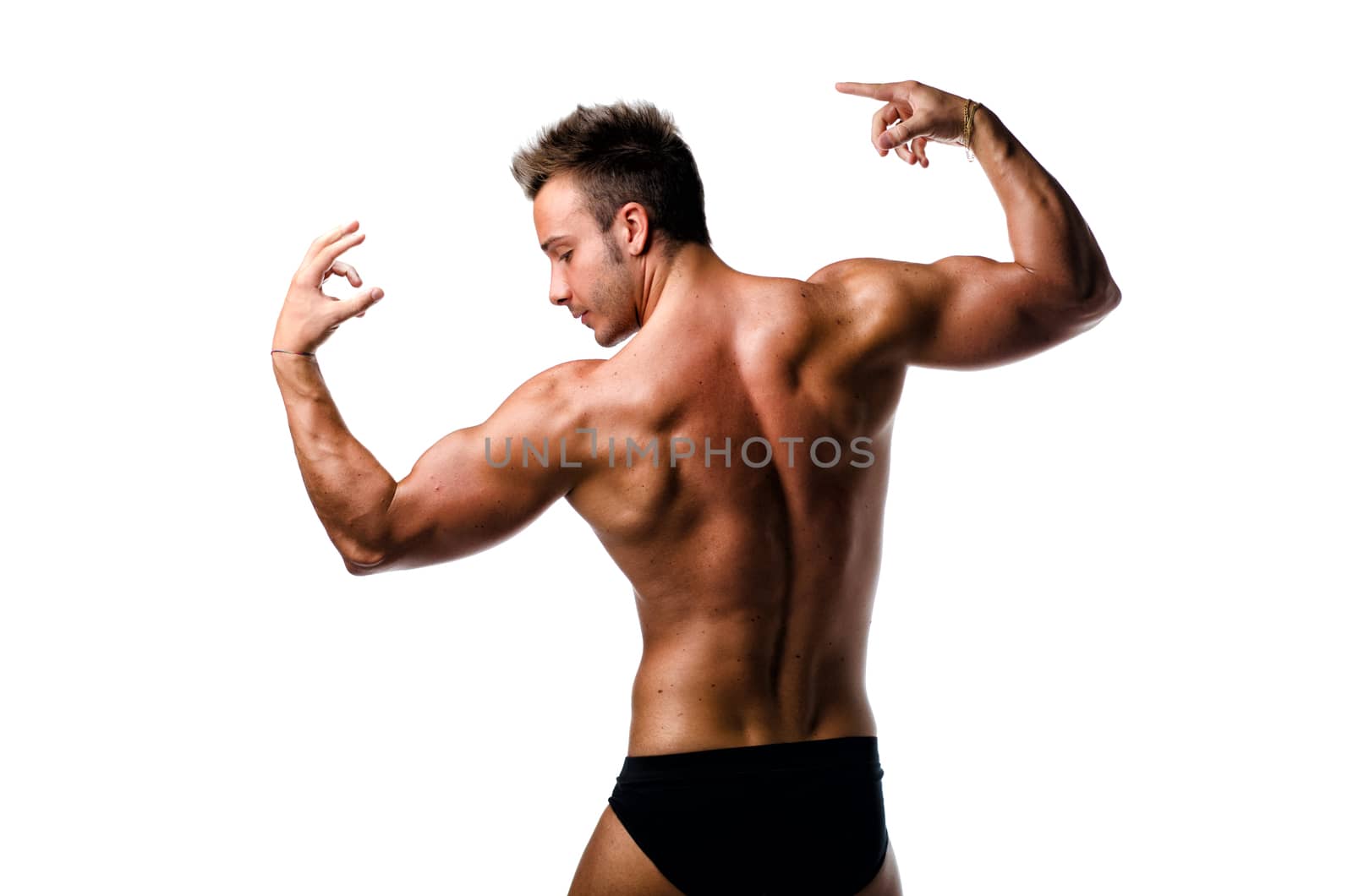 Handsome young muscle man showing muscular back and arms in a pose isolated on white