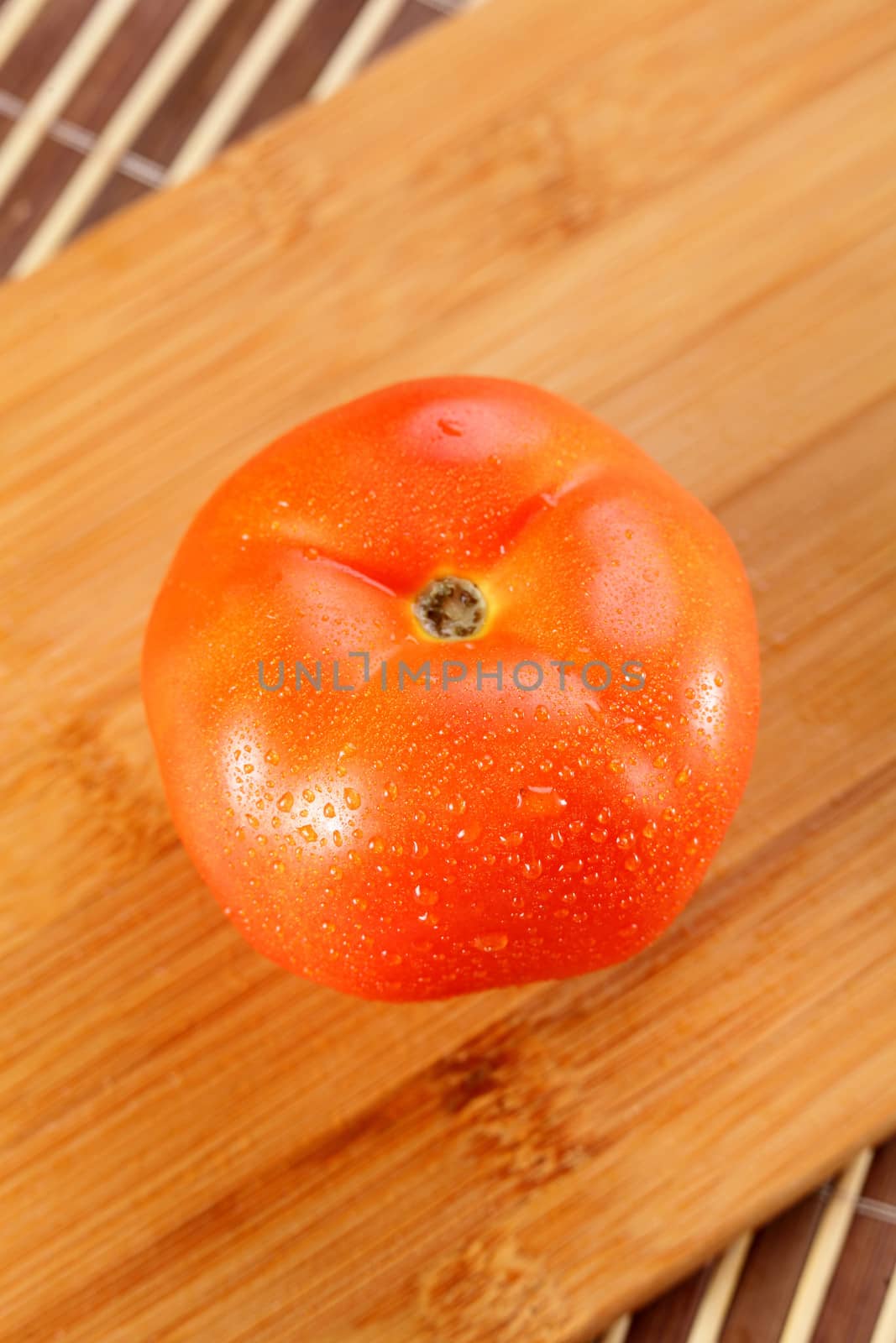 fresh tasty and wet tomato on wooden background