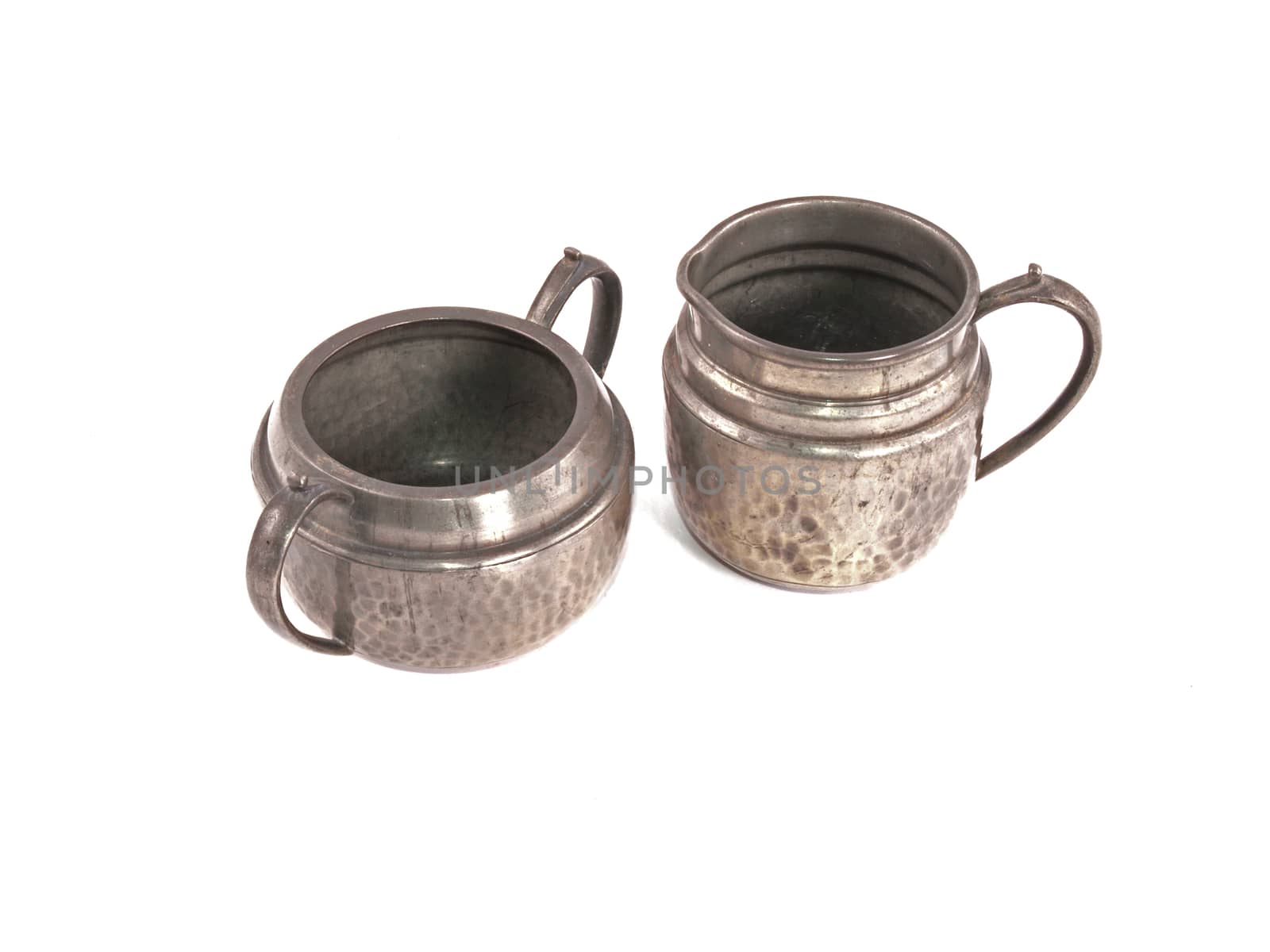 Pewter sugar bowl and milk jug on a white background.
