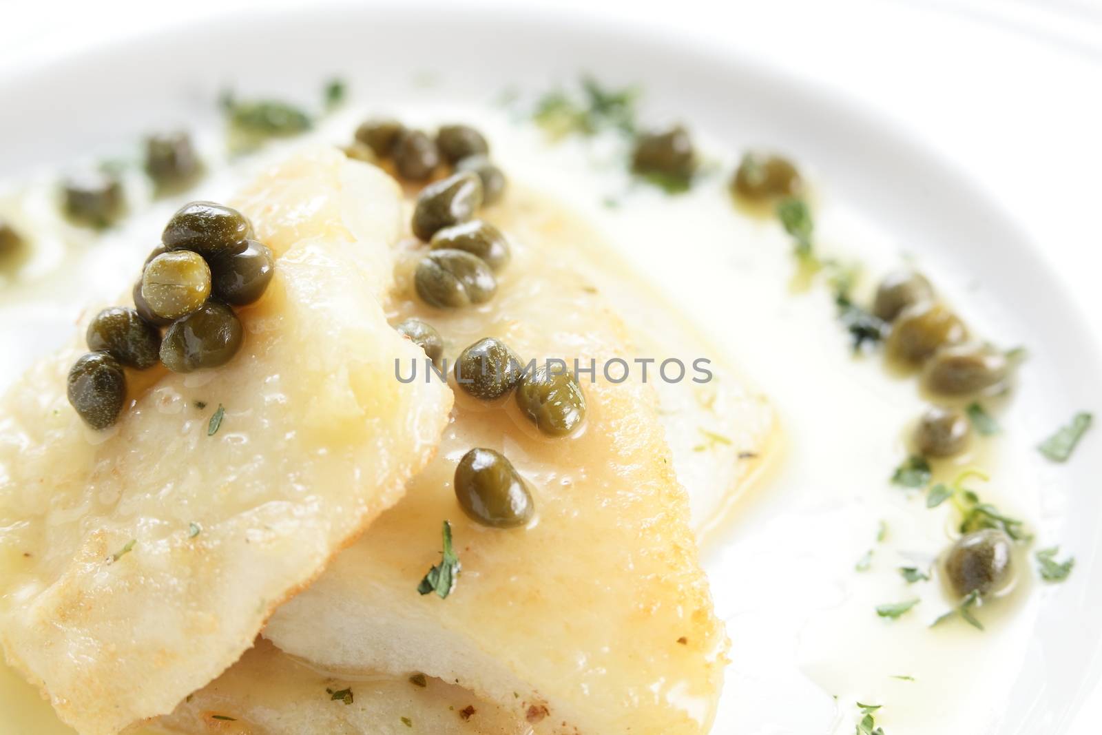 roasted peaces of fish with garnish on white background