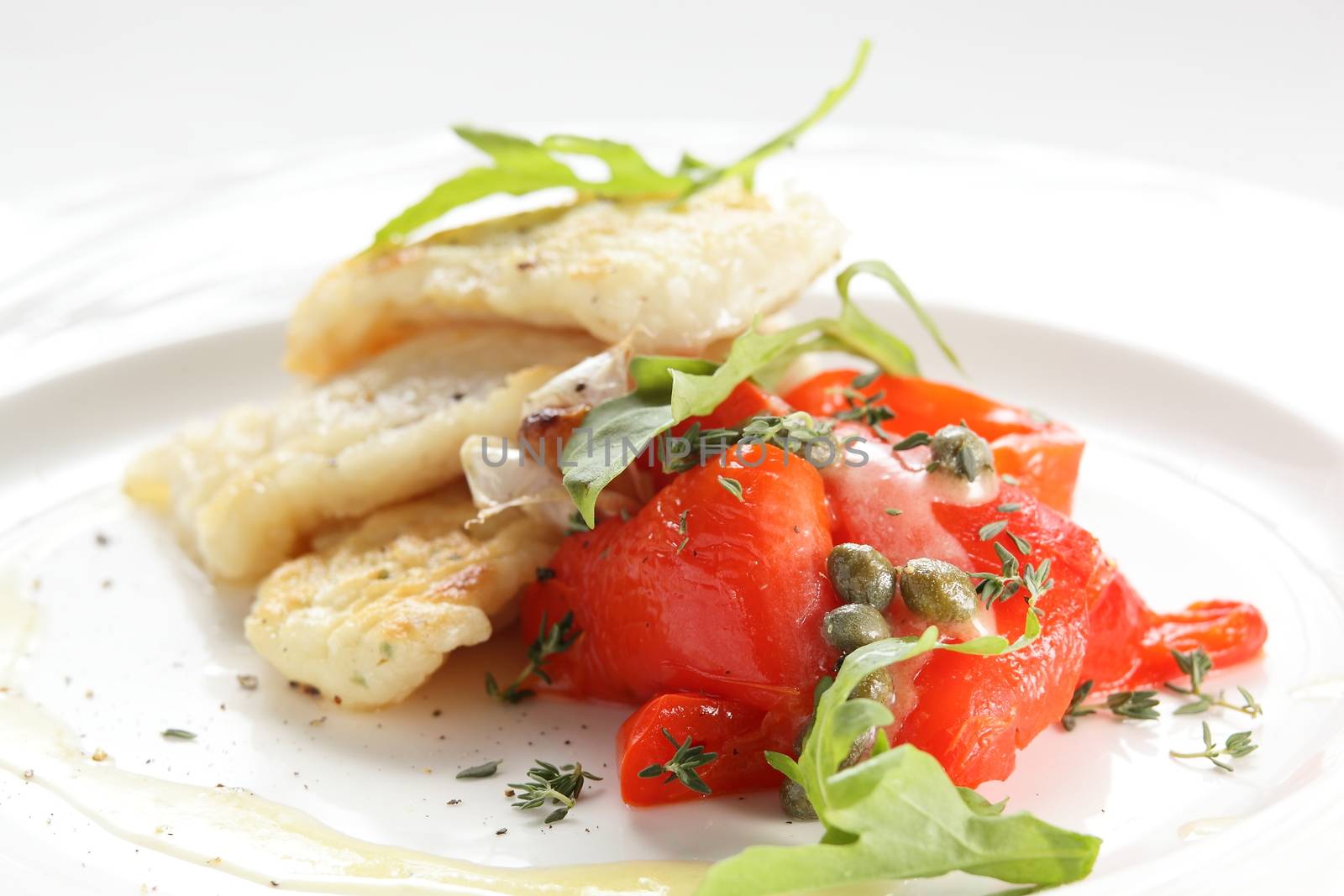 roasted peaces of fish with garnish on white background