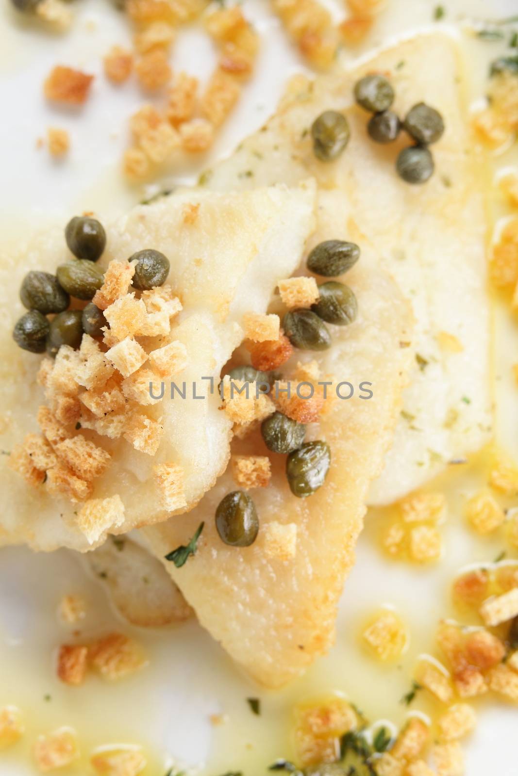 roasted peaces of fish with garnish on white background