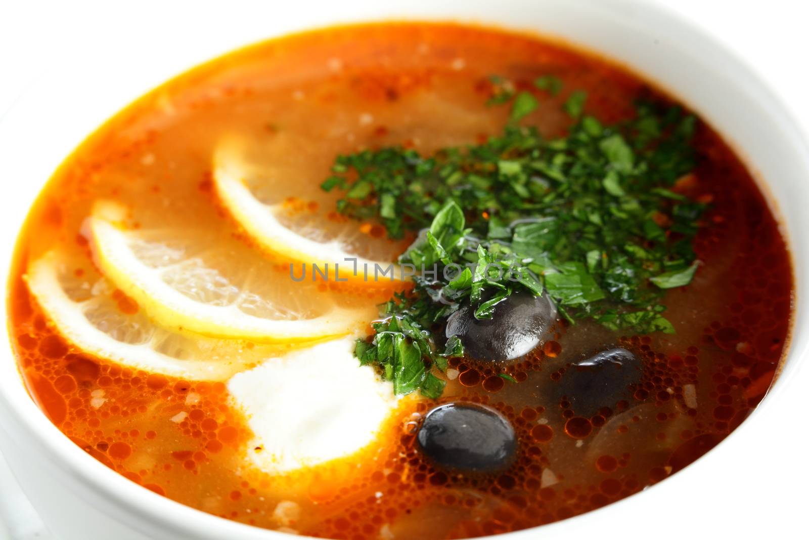 hot soup with sauce and lemon on white background