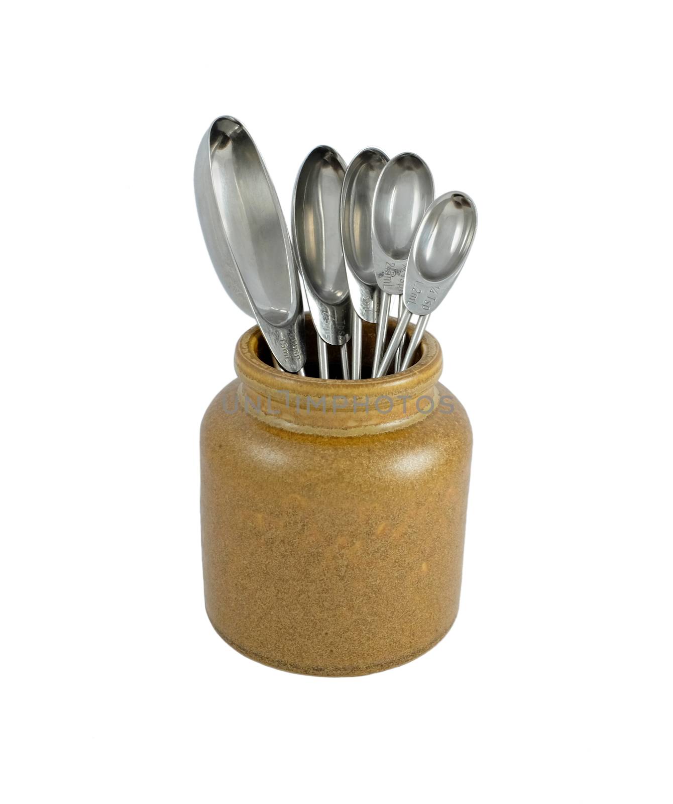 Brown ceramic jar holding metal measuring spoons, isolated on a white background 