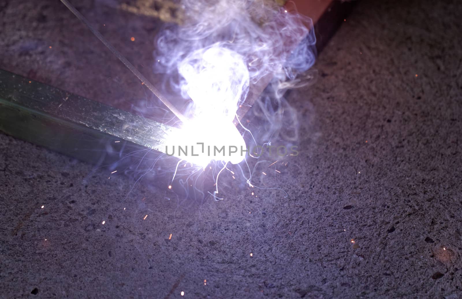 Iron welding with bright light and smoke at manufacturing