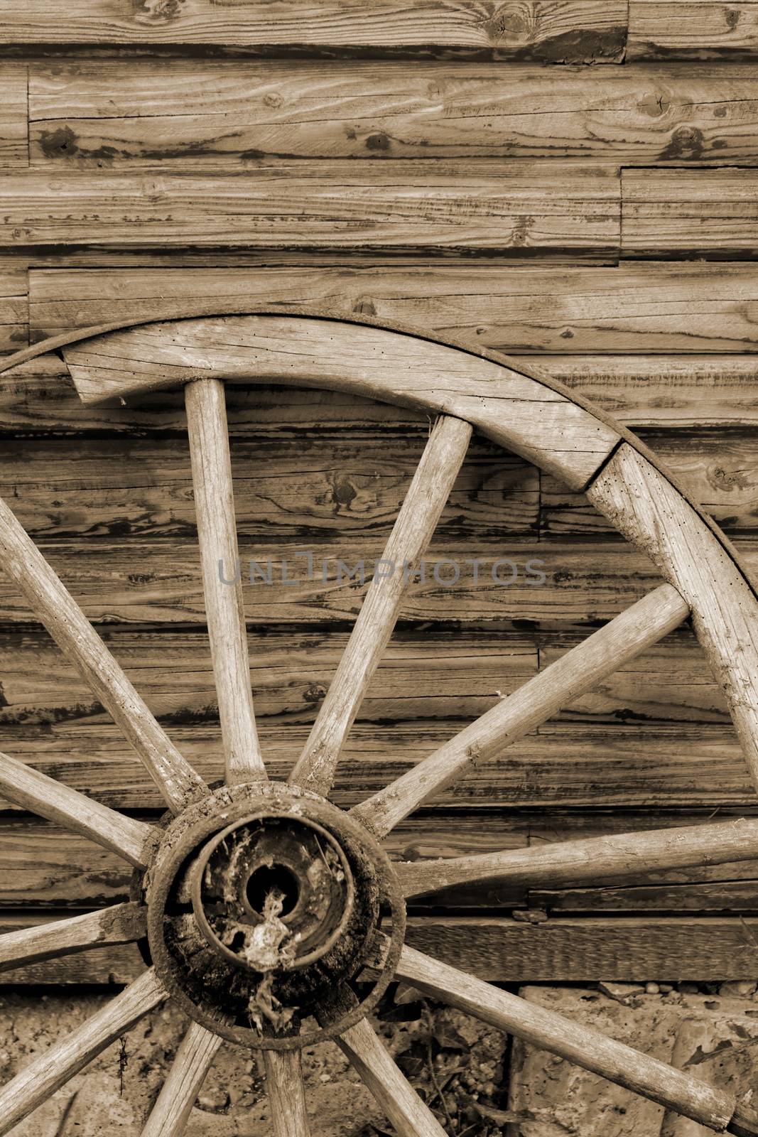 old wagon wheel side by wooden wall