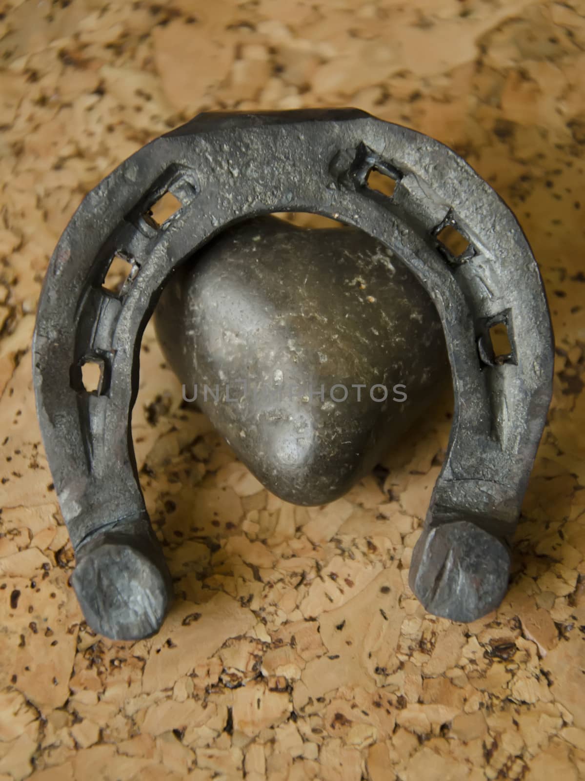 Metal forged heart and horseshoe on a cork background by pt-home