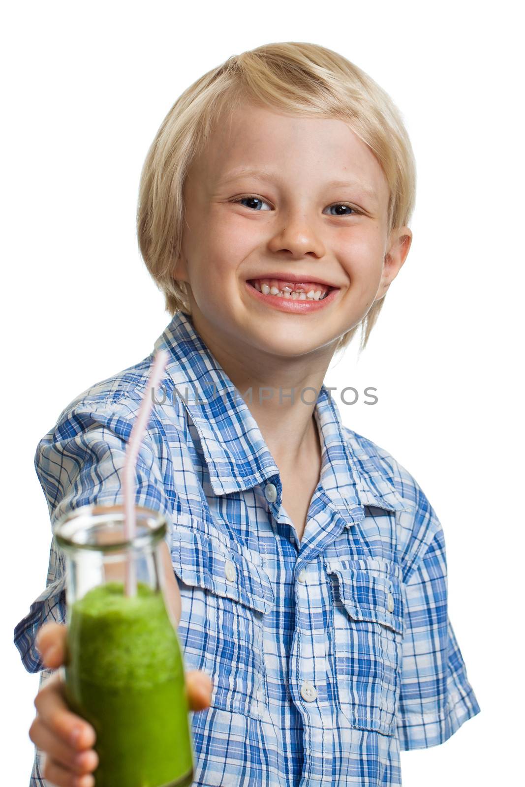 A cute healthy young boy holding a green smoothie or juice smiling. Isolated on white.