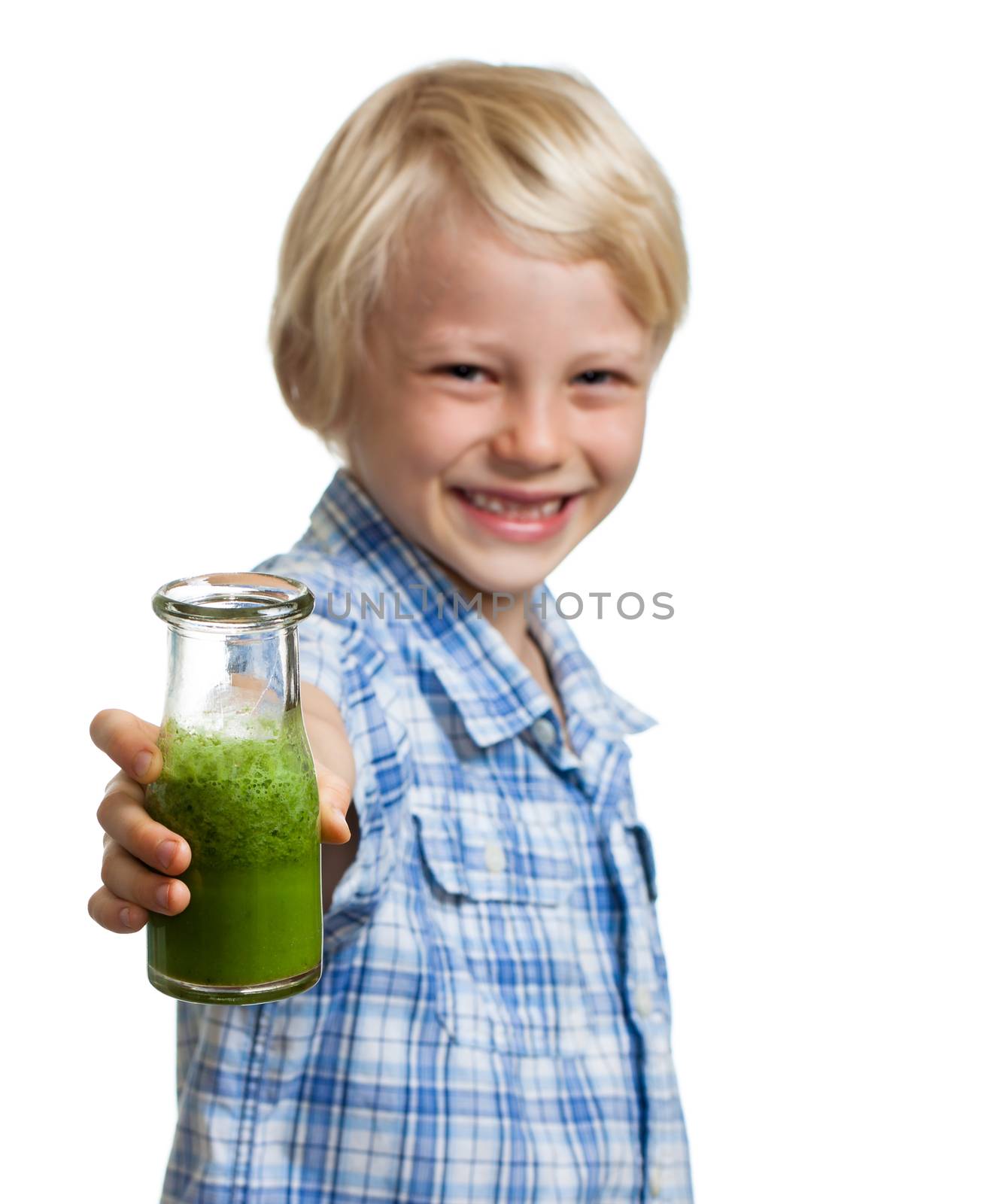 A happy smiling boy holding out a bottle of green smoothie or juice. Focus on smoothie. Isolated on white.