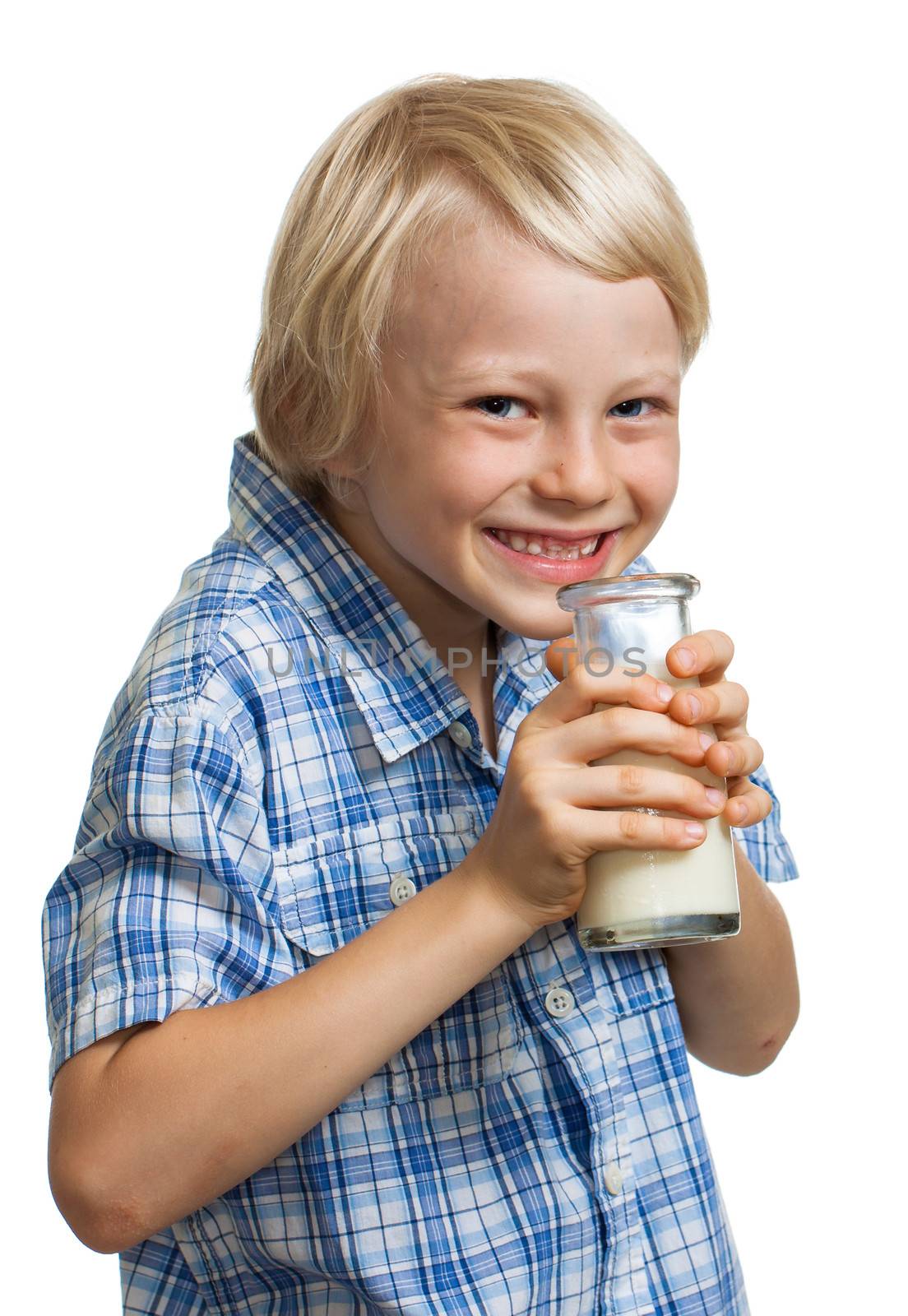 Happy cute boy giggling and holding a bottle of milk to his mouth. Isolated on white.