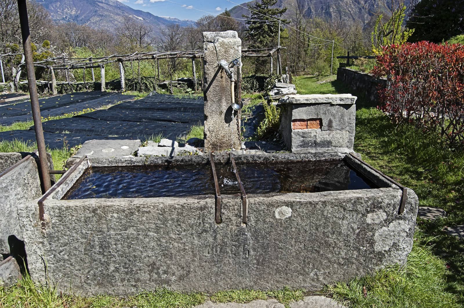 stone fountain at alpine village, italian alps