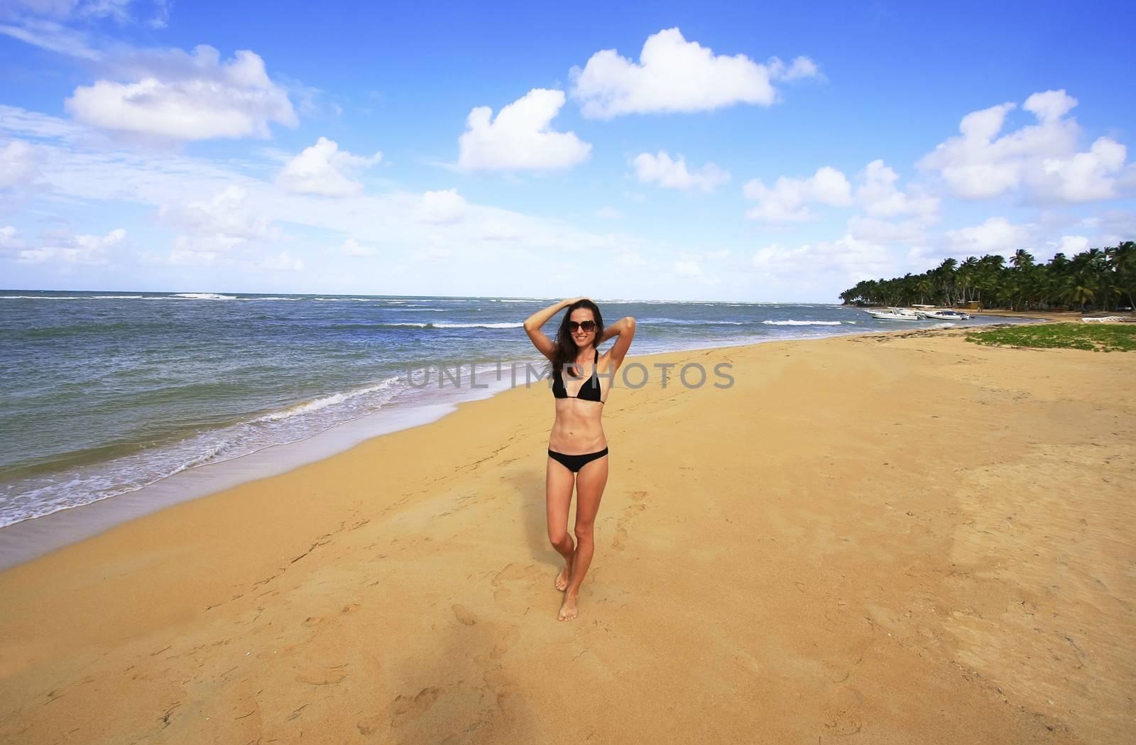 Young woman in bikini walking on Las Terrenas beach, Samana peni by donya_nedomam