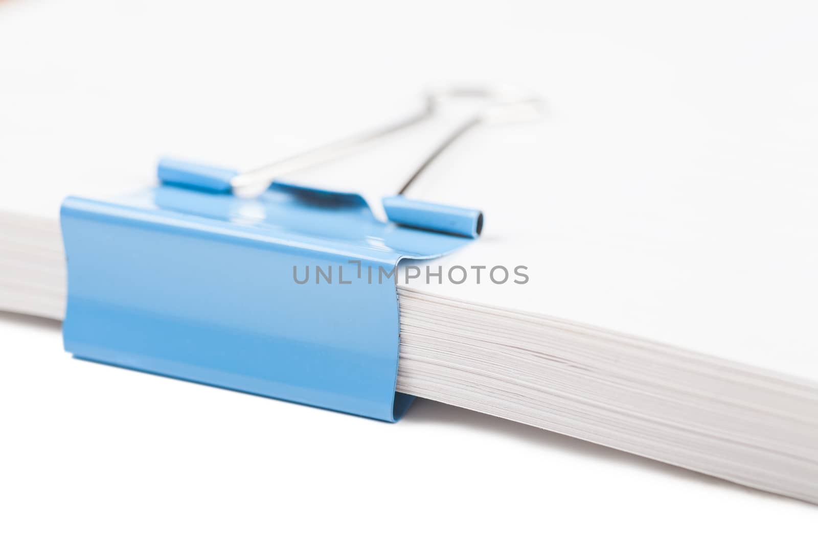 Macro view of blue clip on a bunch of paper sheets